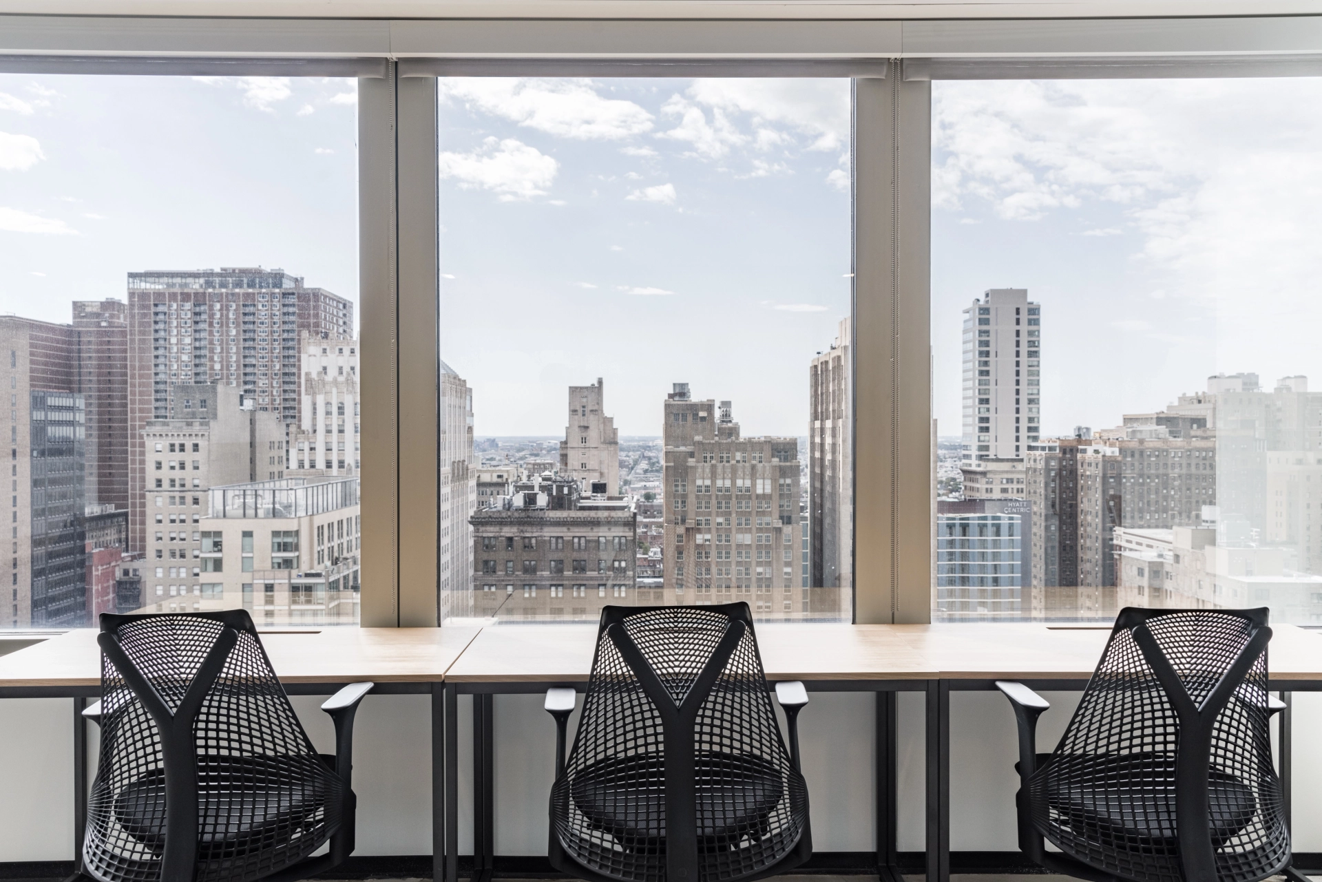 Two black chairs in an office workspace with a view of Philadelphia.