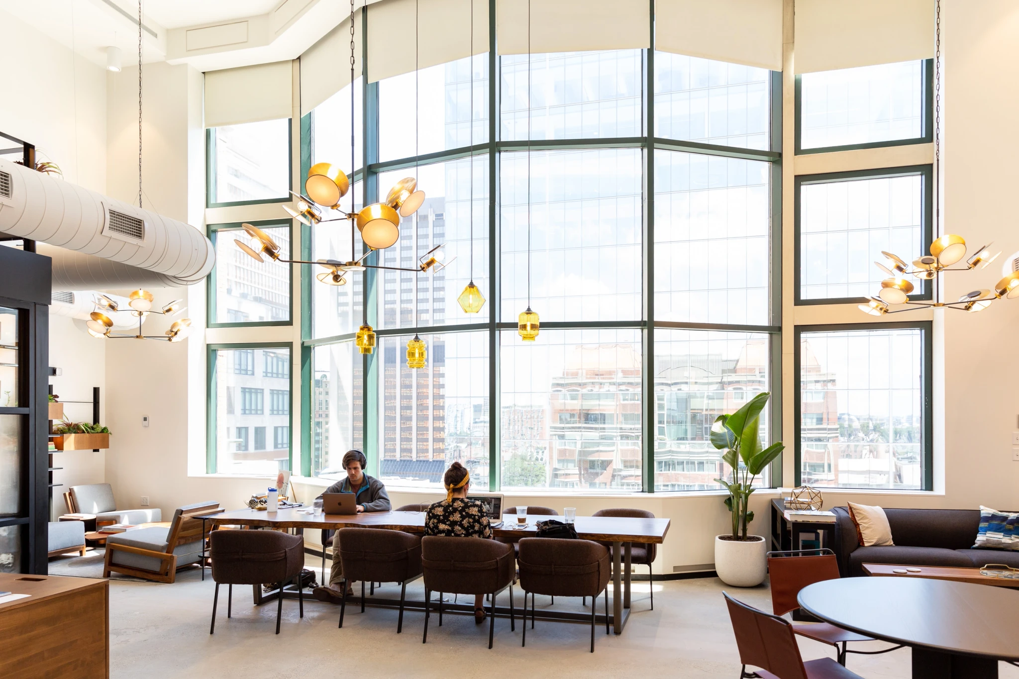 A coworking meeting room in Boston with people sitting around a table.