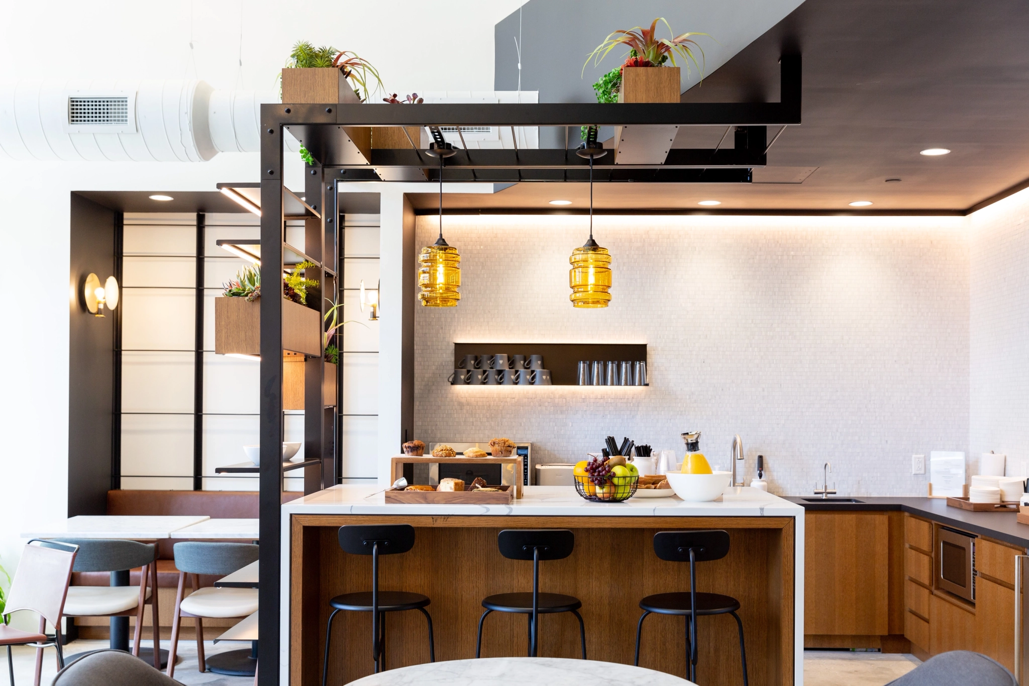 a modern workspace with a kitchenette and high stools.