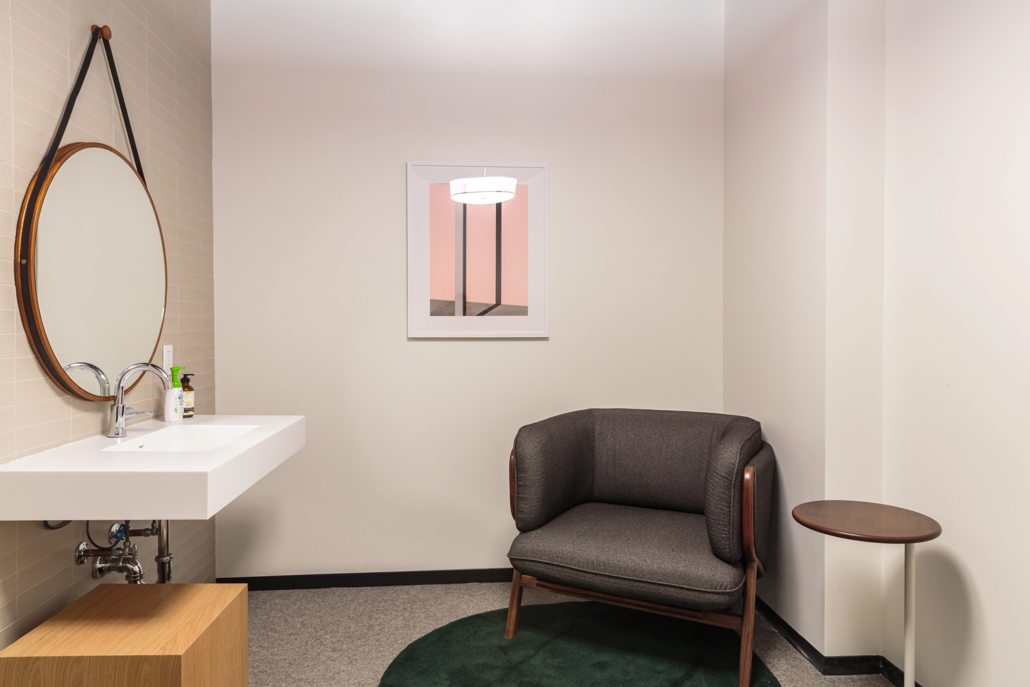 A coworking office in Manhattan with a bathroom featuring a chair and a mirror.