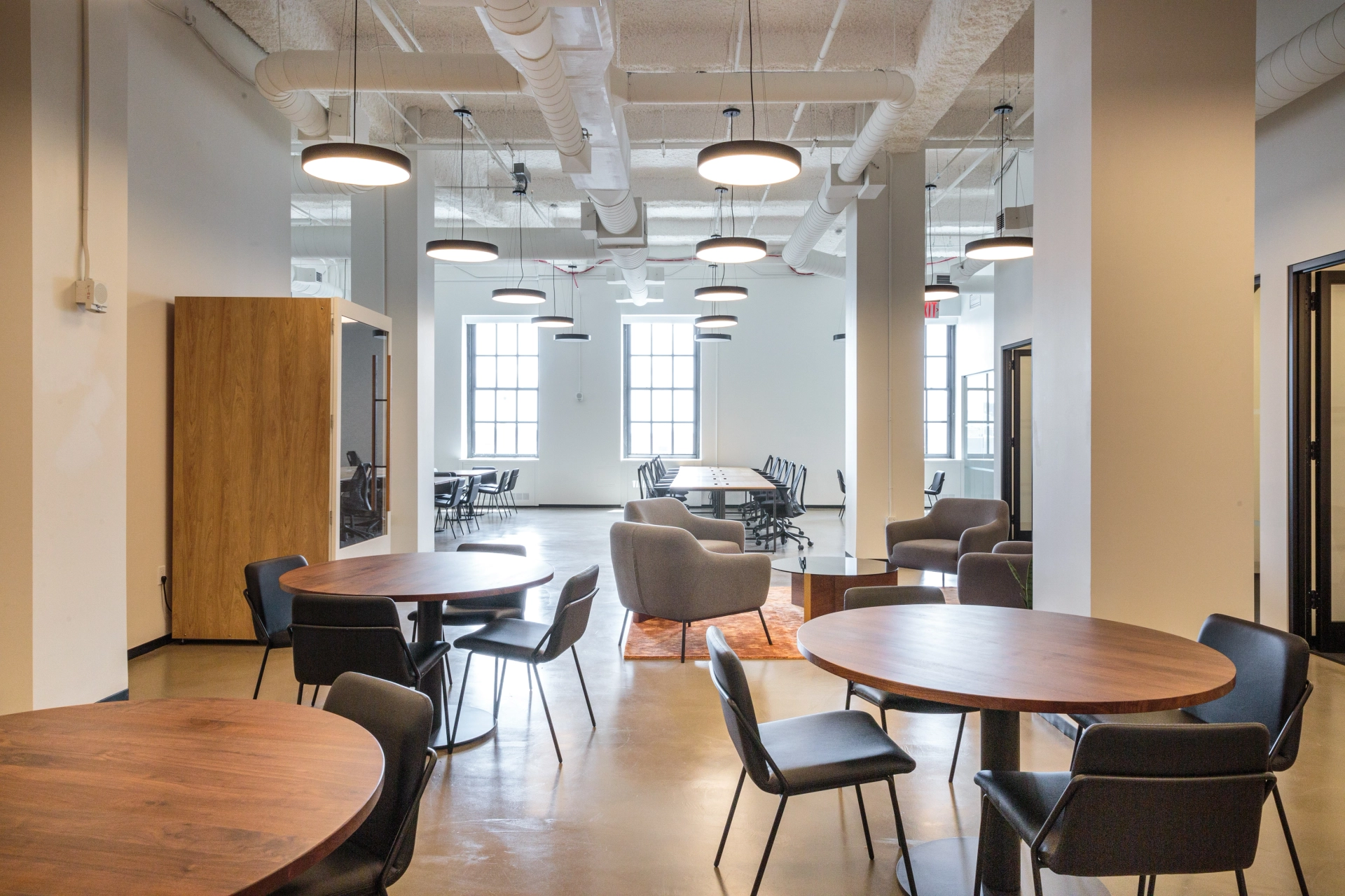 A coworking space equipped with tables and chairs for an open office environment.