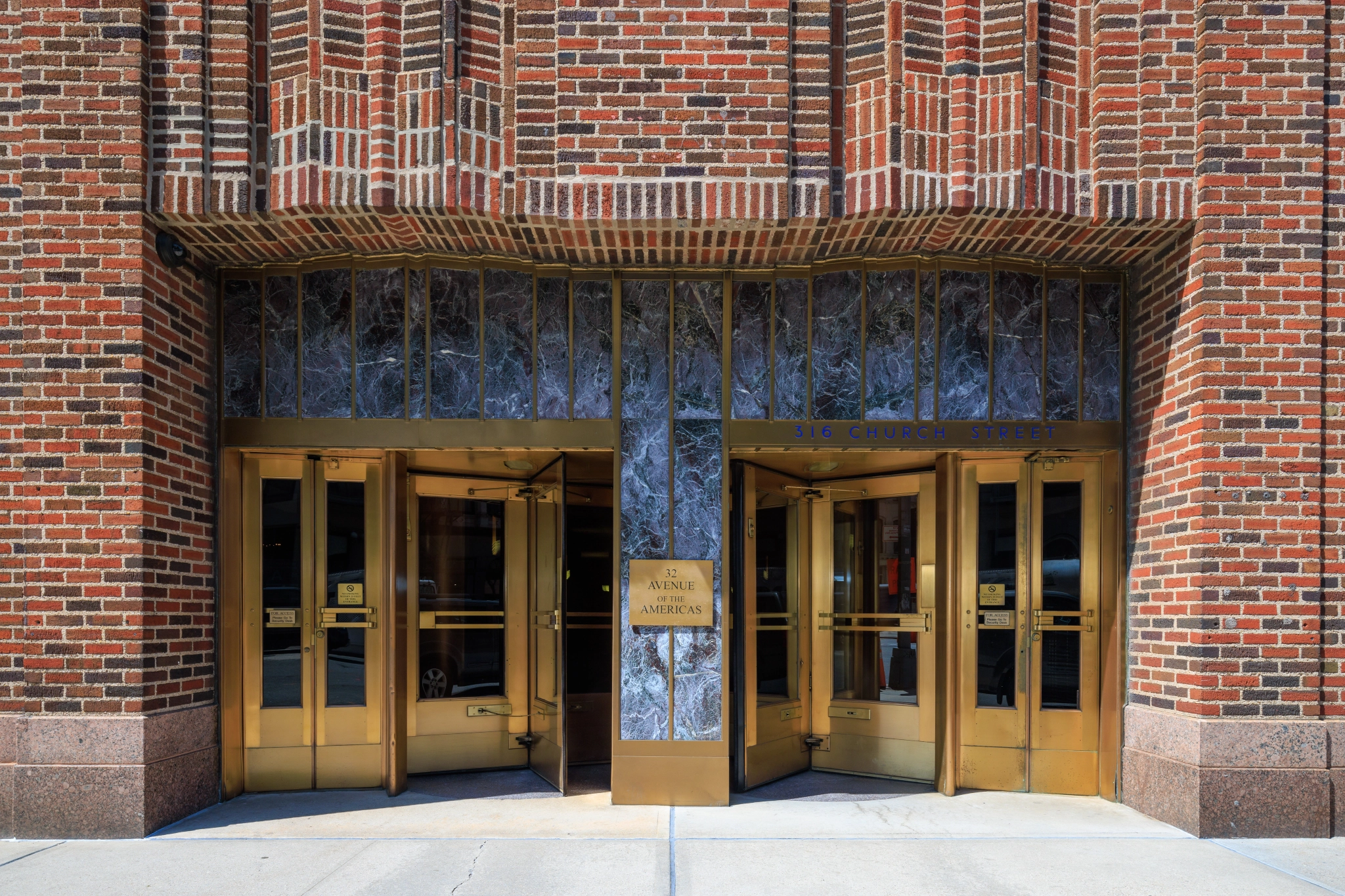 The entrance to a workspace building with gold doors.