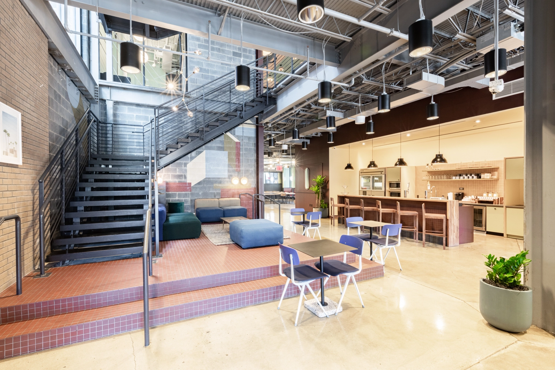 Un espace de coworking à Washington avec un design de bureau moderne avec un escalier et des canapés.