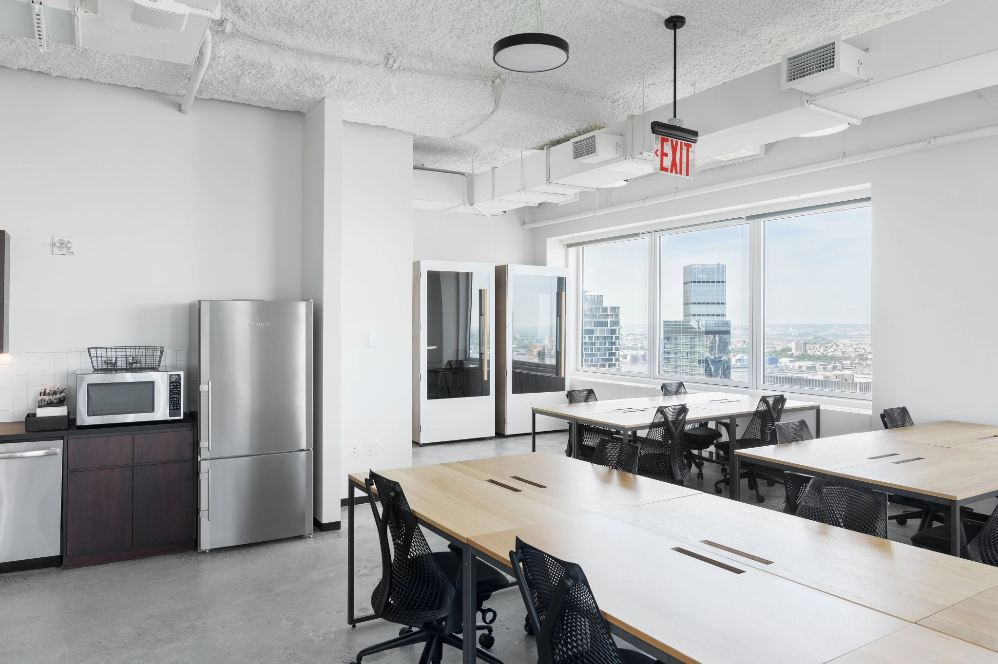 A New York office workspace with tables and chairs and a view of the city.