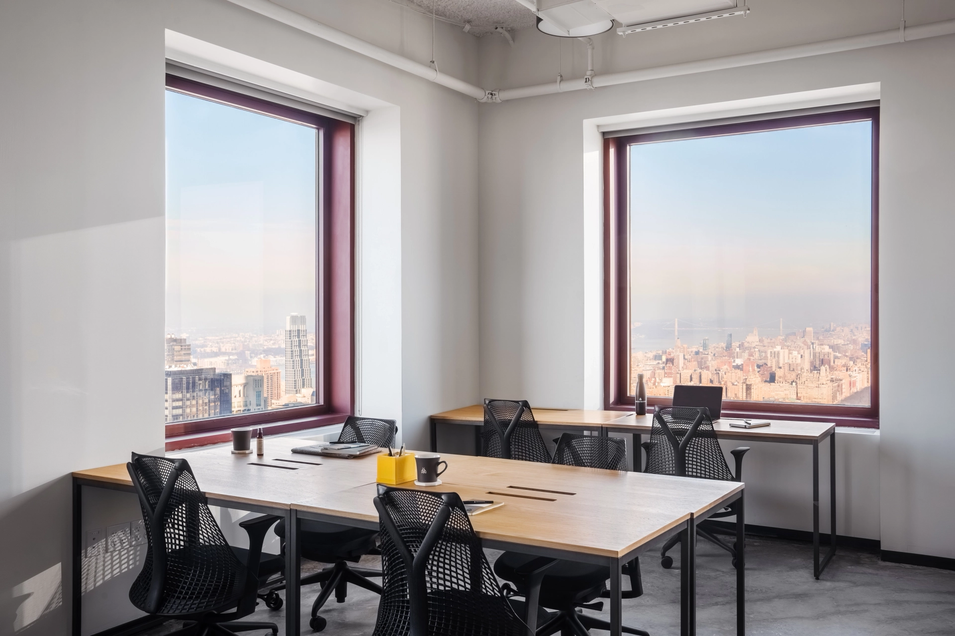 Un bureau de coworking avec de grandes fenêtres donnant sur New York.
