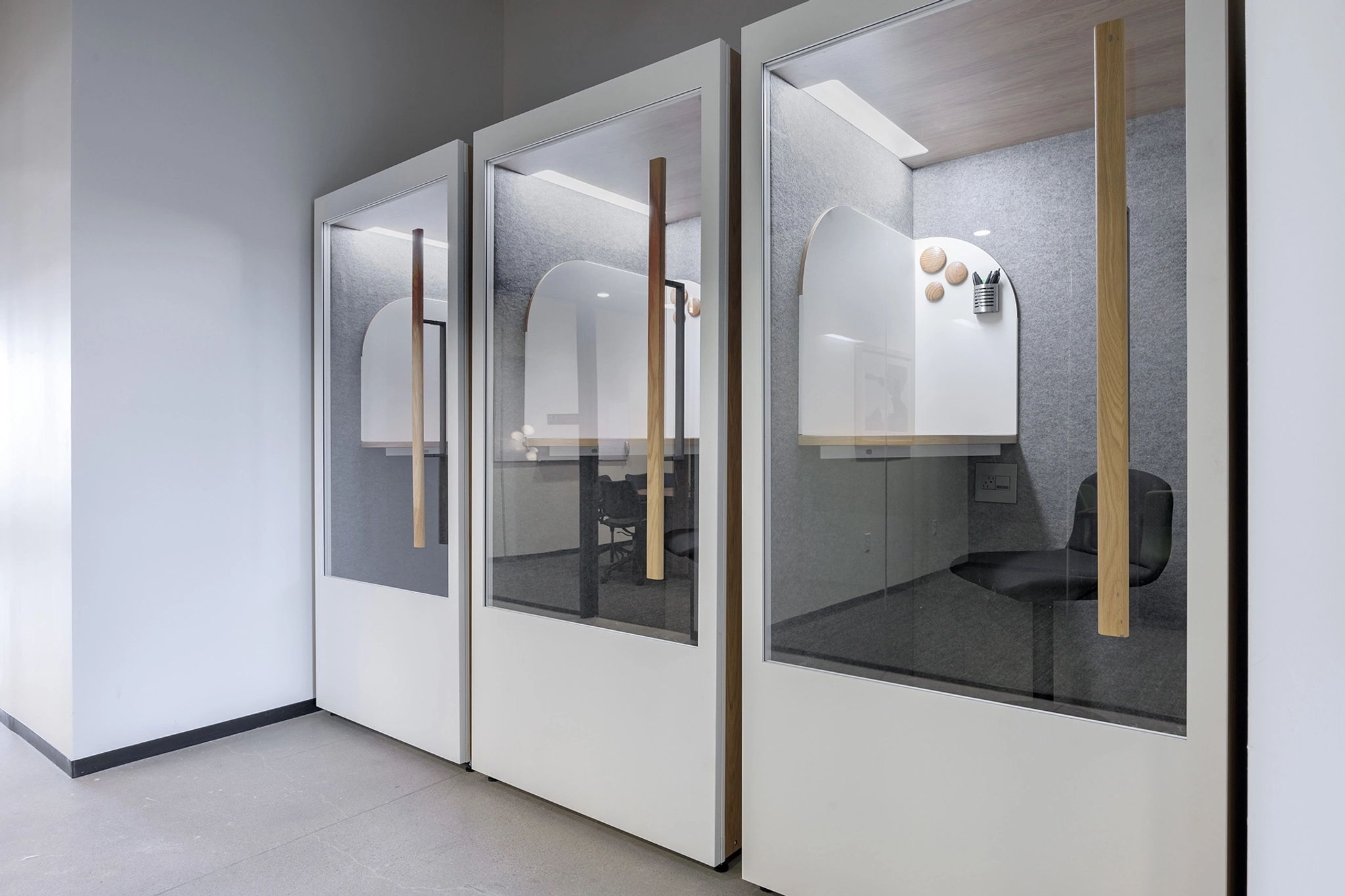 A white cubicle with a glass door in a Scottsdale office workspace.