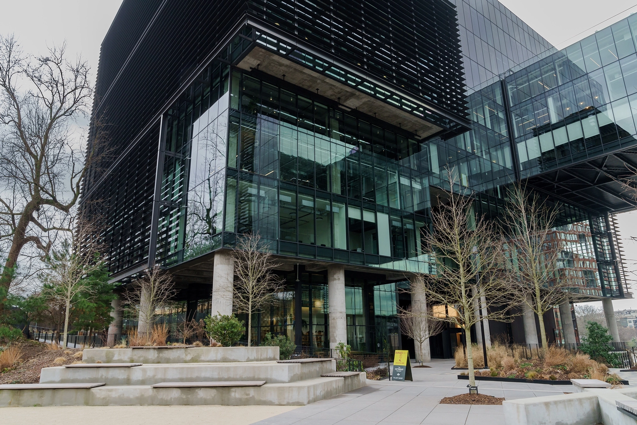 A large glass office building with trees in front of it.