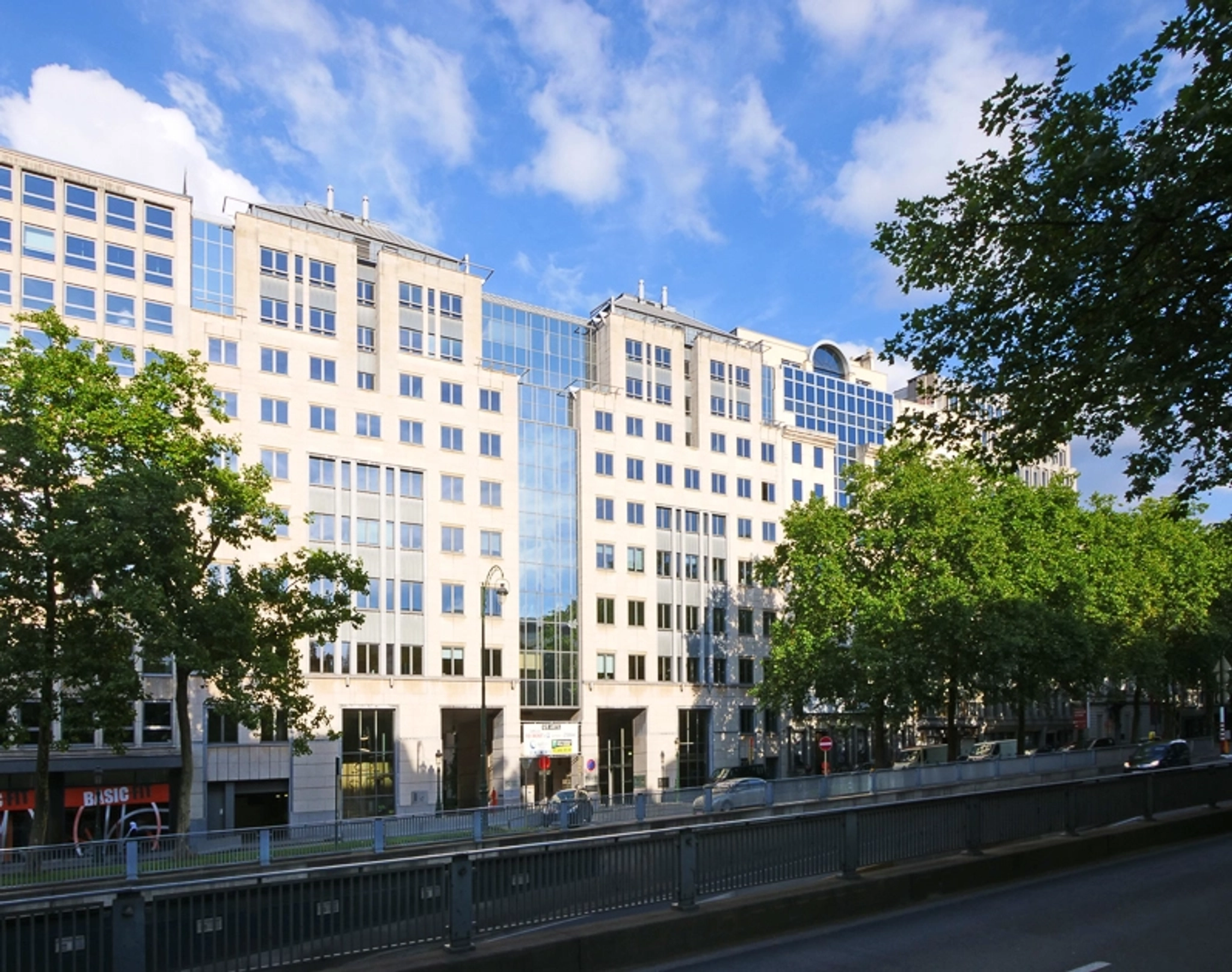 Ein großes Bürogebäude mit Bäumen im Hintergrund.