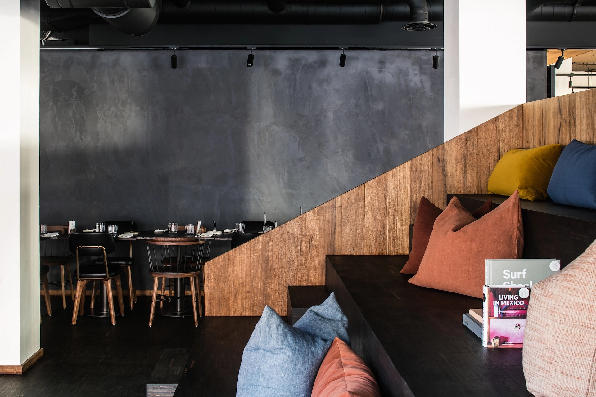 A coworking space in Eindhoven with a wooden floor and colorful pillows.