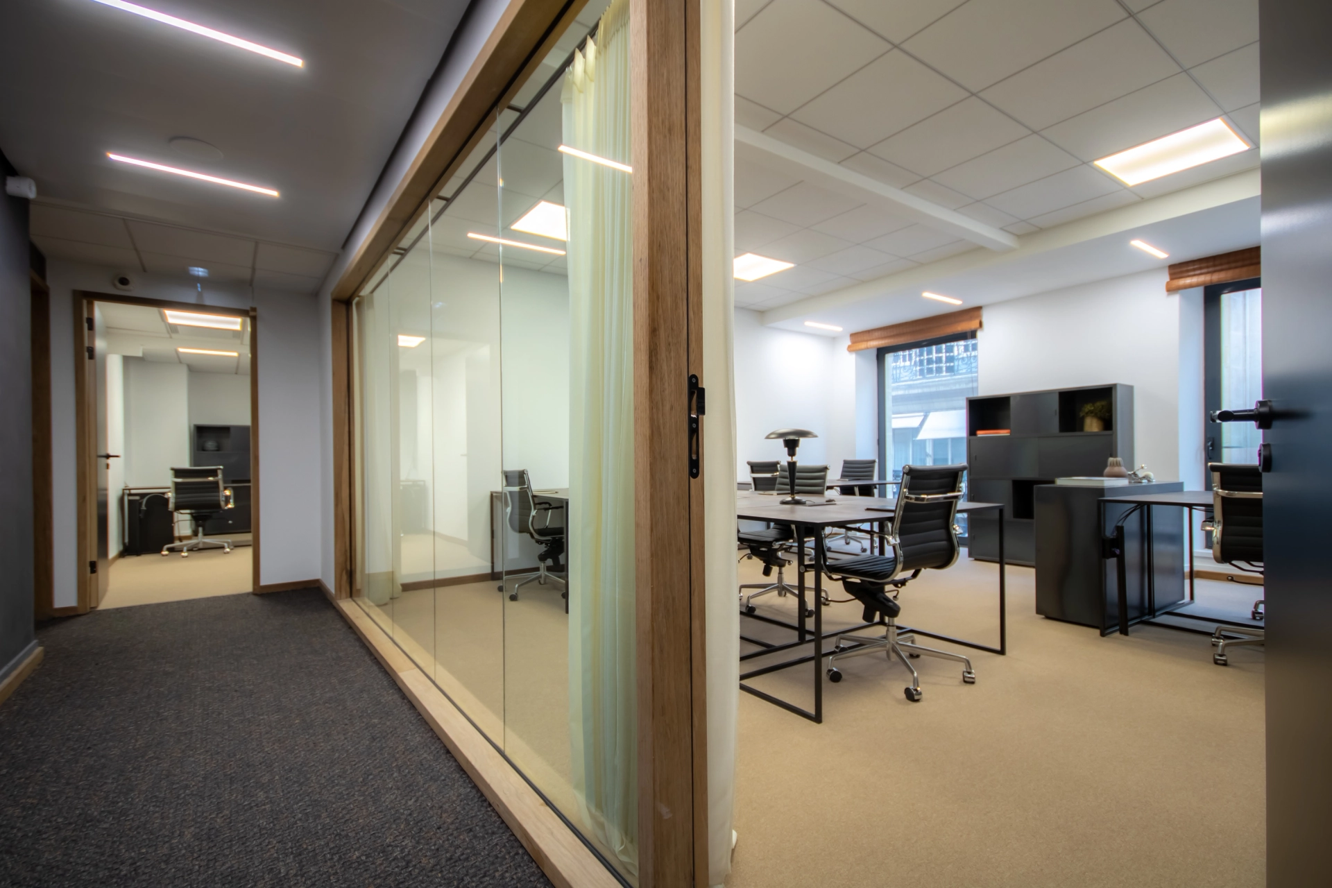 a sleek coworking office with glass doors and a desk.