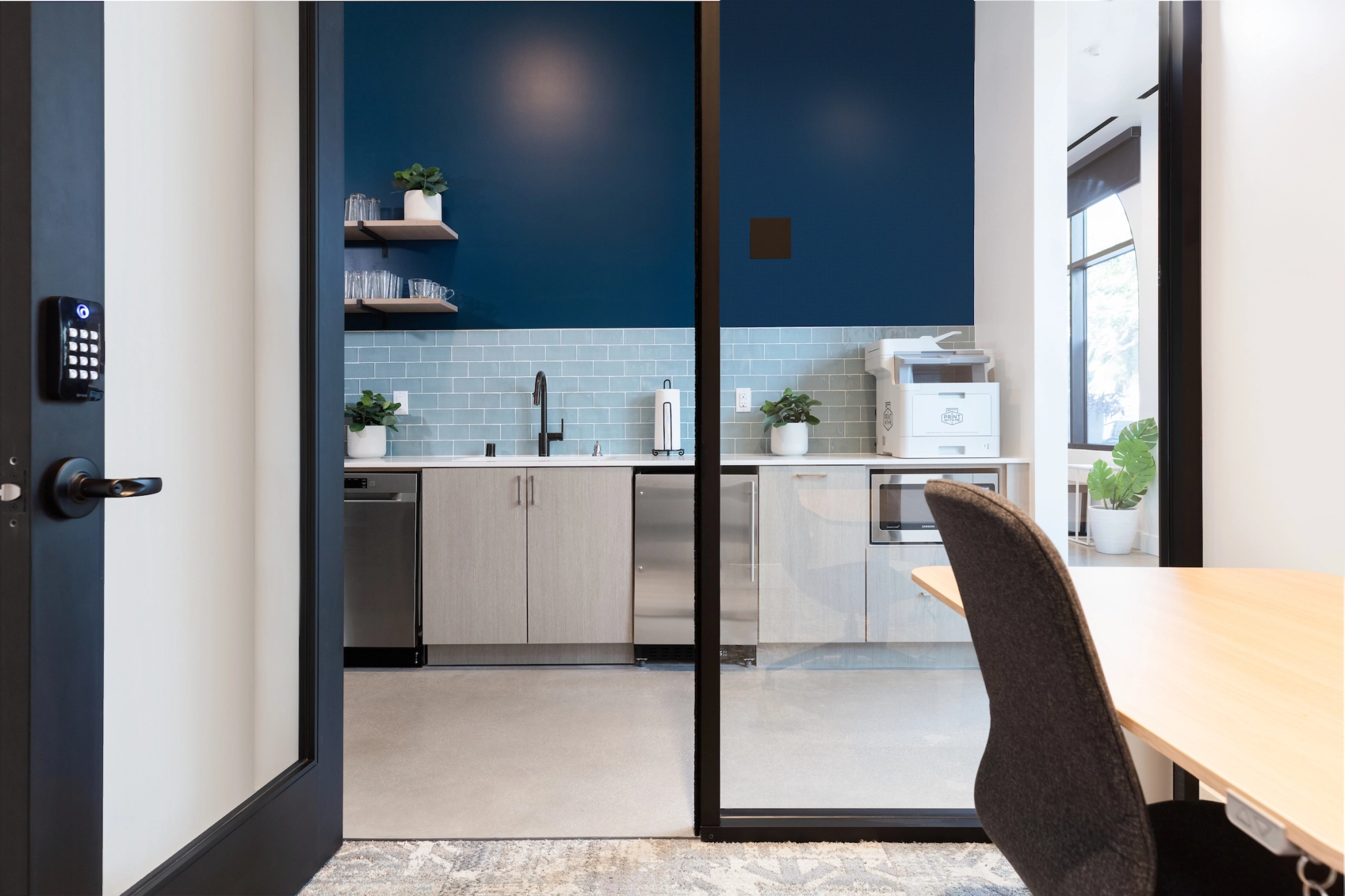 An office meeting room with a glass door and blue walls.