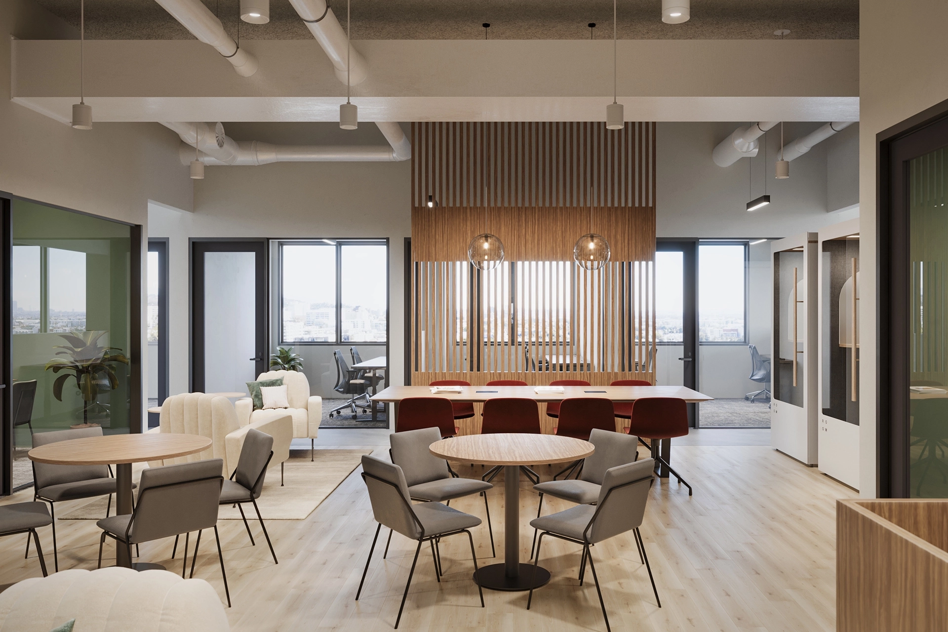 Modern office workspace with varied seating styles, wood accents and pendant lighting. Large windows offer views of the Los Angeles skyline.