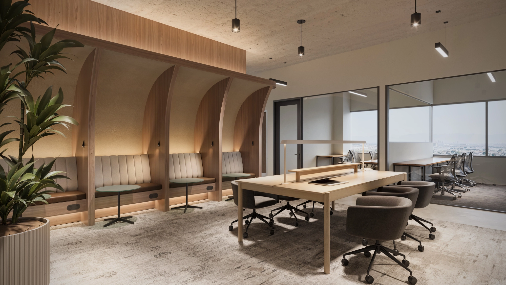 Modern coworking office space with wooden workstations, swivel chairs, built-in booth seating, large windows, and potted plants.