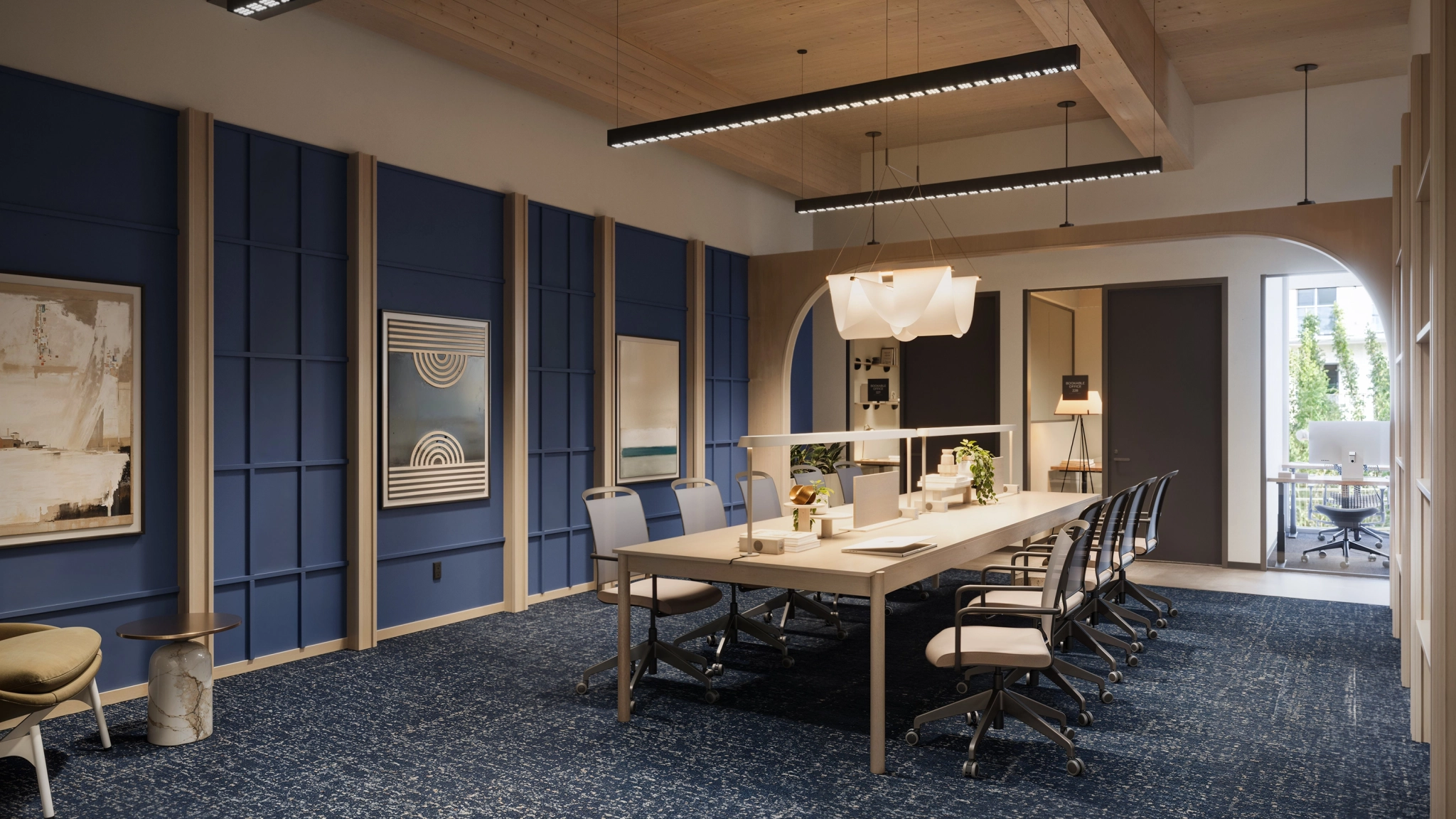 Modern conference room with a long table, several office chairs, blue accent walls, contemporary lighting, and art decor—an ideal workspace in Marina del Rey. A doorway leads to another office space in the background.