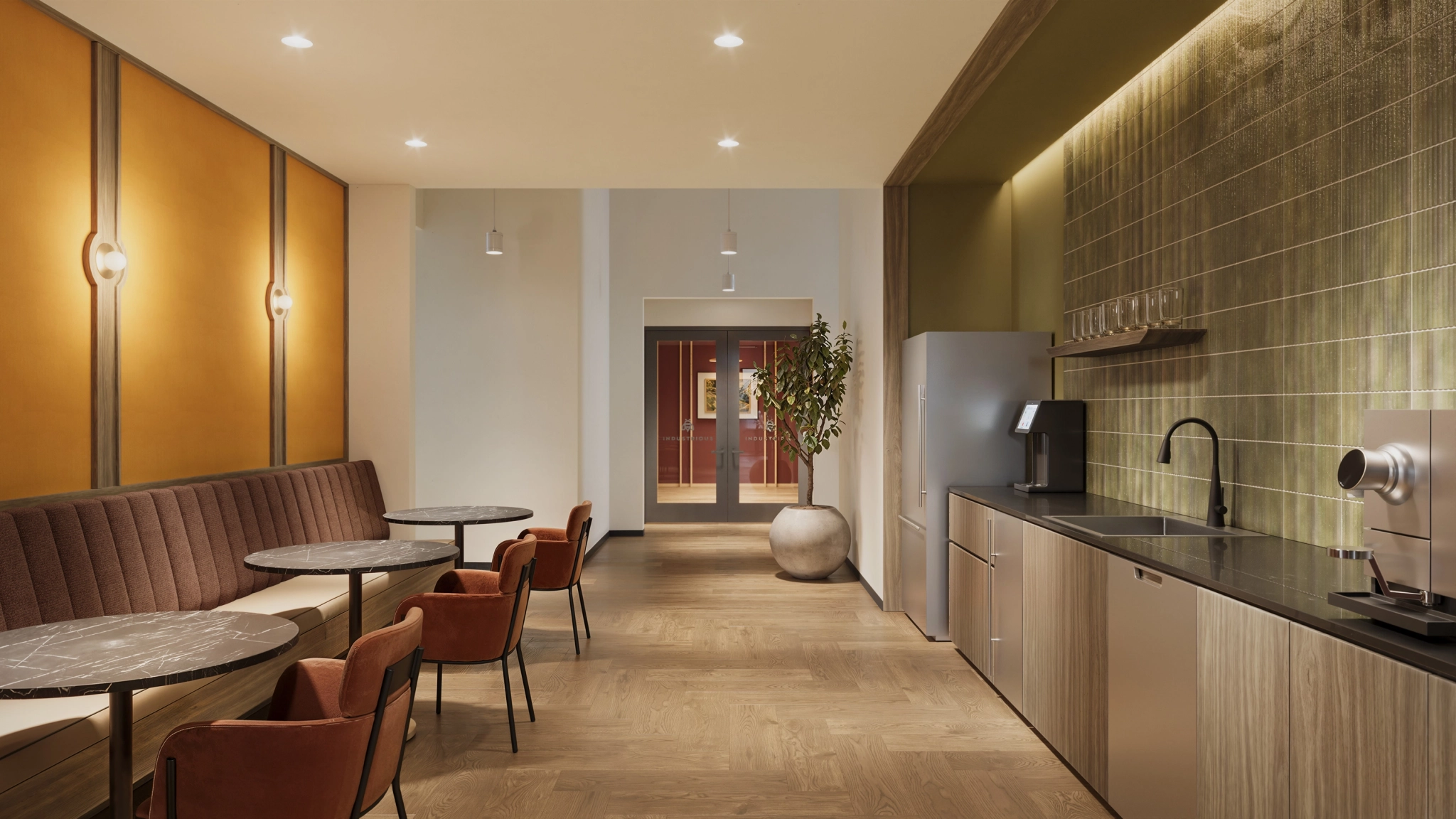 Modern office kitchen and seating area with tables, chairs, built-in bench, kitchenette, refrigerator, coffee machines, a potted plant—perfect for coworking or casual meetings in the heart of New York.