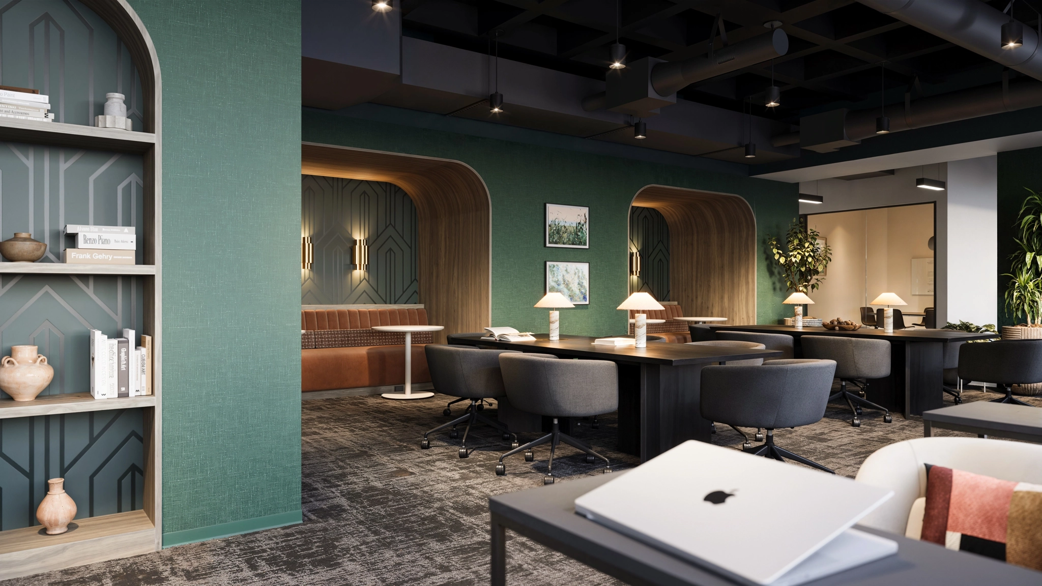 Modern co-working office in New York with dark desks, gray chairs, table lamps, built-in seating alcoves, and green accent walls. Open shelves with books and decor are visible in the foreground; a meeting room is nearby.