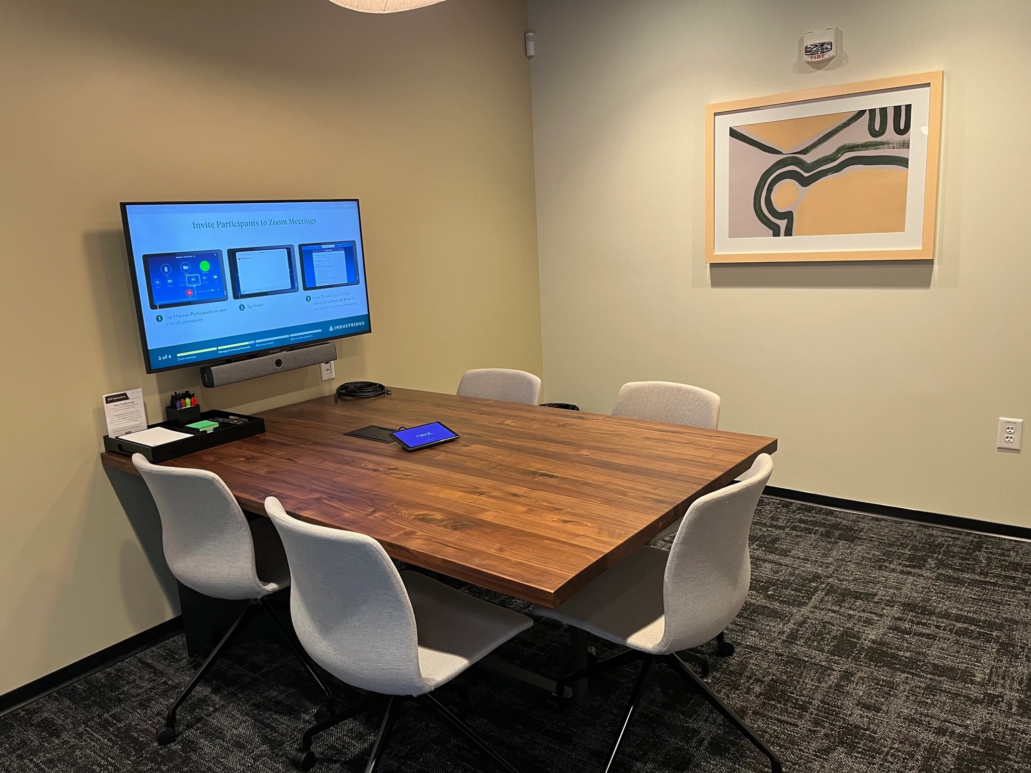 Een coworking-vergaderruimte uitgerust met een tafel, stoelen en een televisie.