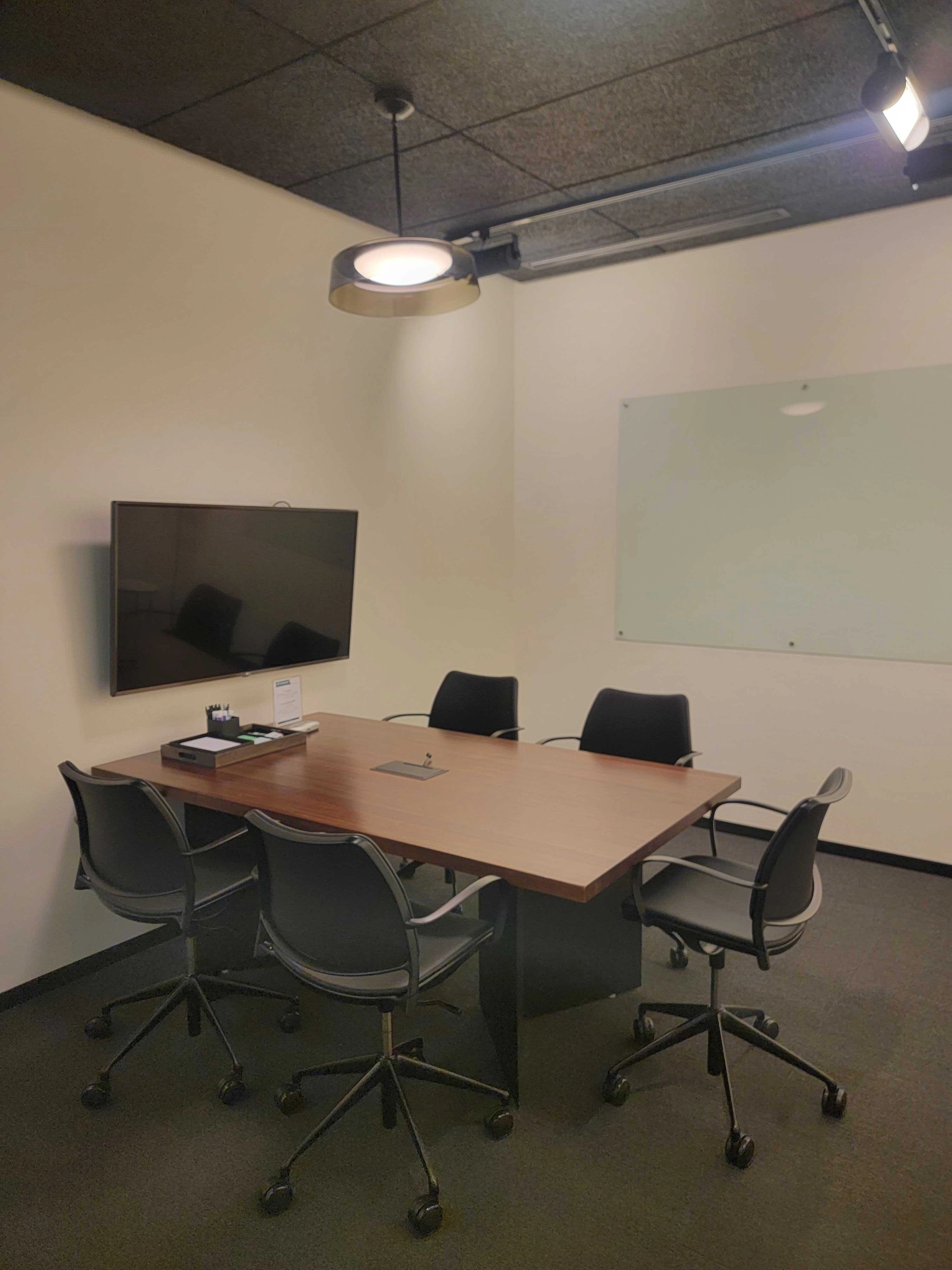 An office conference room in a coworking space in Chicago, equipped with a table and chairs.