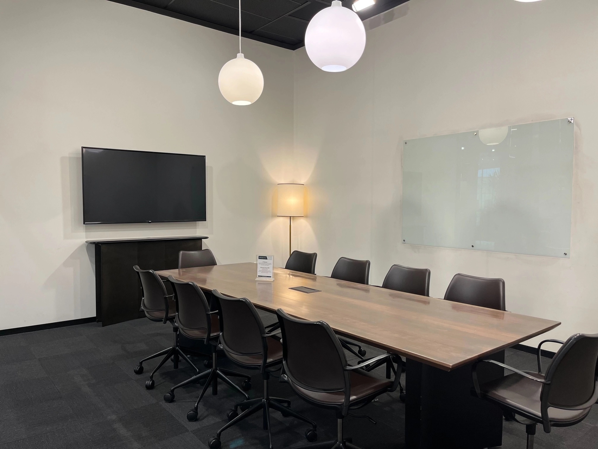 Une salle de conférence spacieuse meublée d'une grande table et de chaises, conçue pour accueillir des réunions collaboratives ou des séances de coworking.