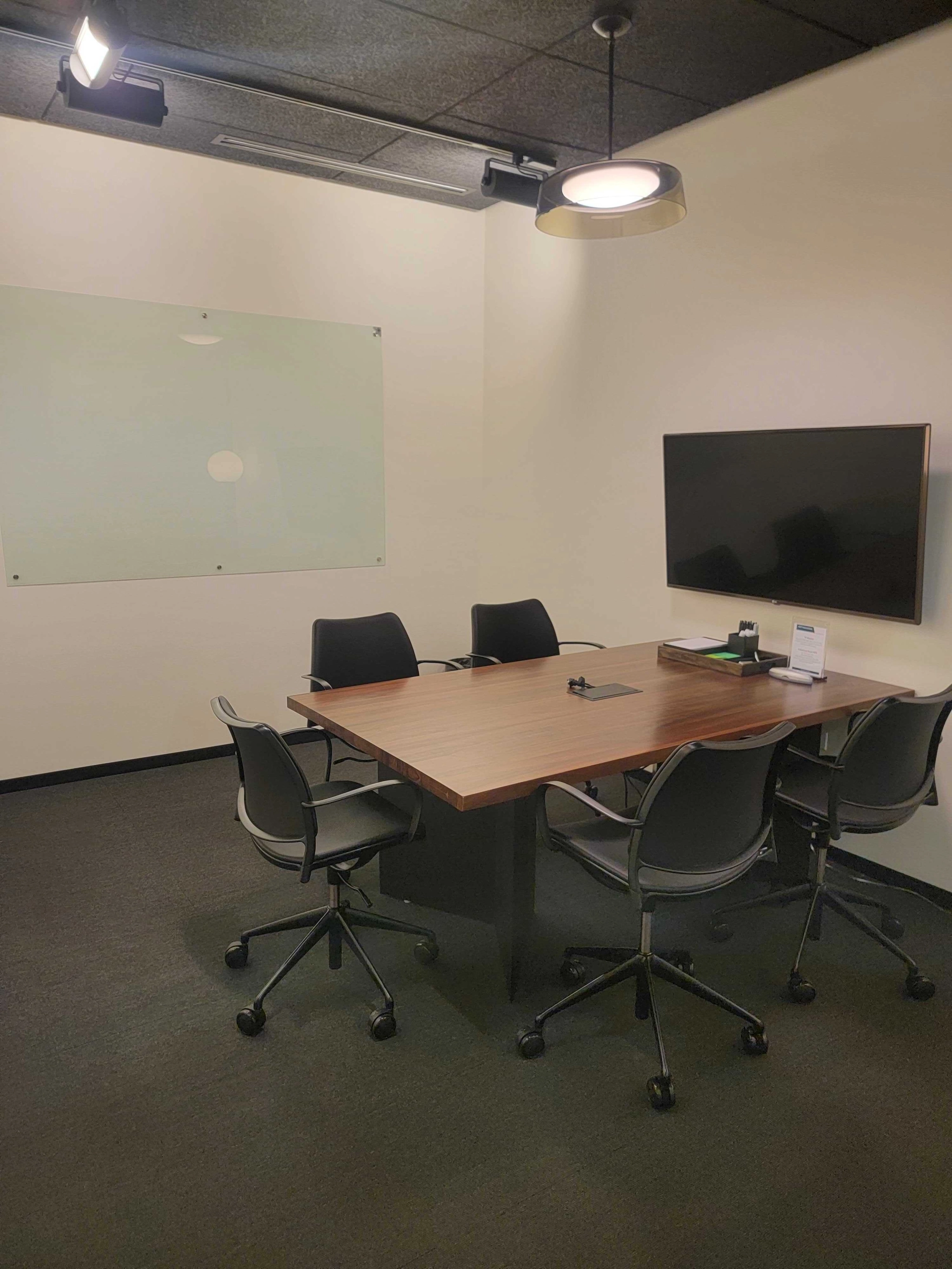 An office conference room furnished with a table and chairs.