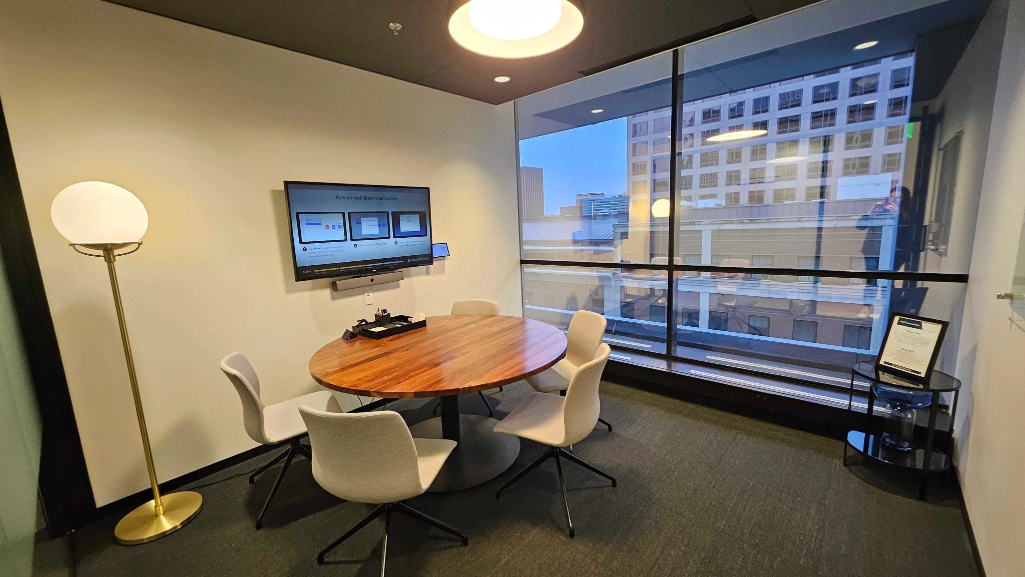 An office meeting room with a table and chairs, offering a scenic view of the city.