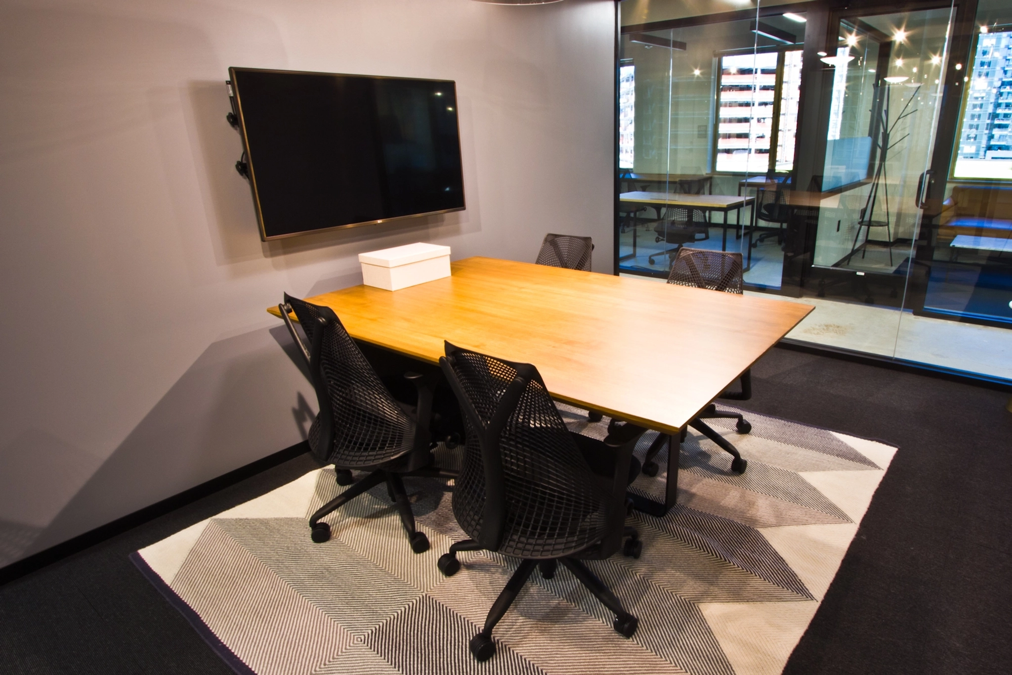 A meeting room in Seattle equipped with a table, chairs, and a TV.