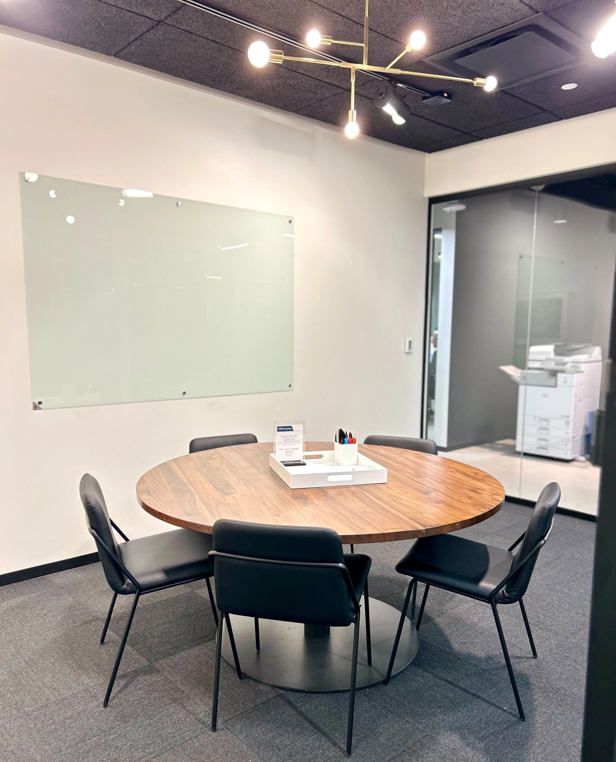 A meeting room with a round table and chairs in a Boston office.