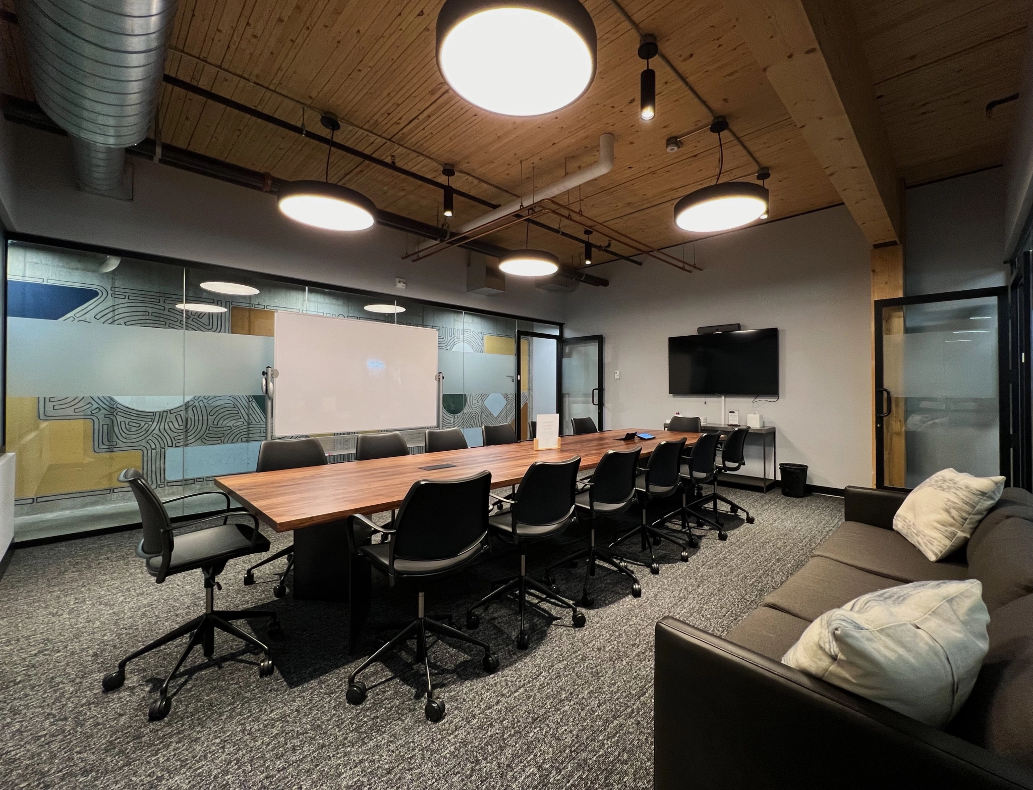 Une salle de conférence spacieuse avec une grande table et des chaises, parfaite pour des réunions ou du coworking.