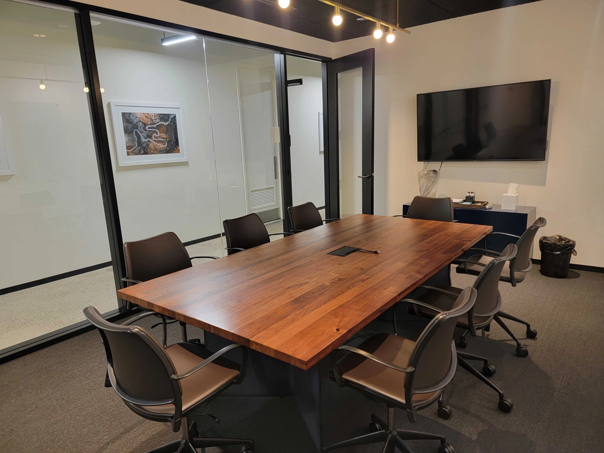 An office conference room with a wooden table and chairs.