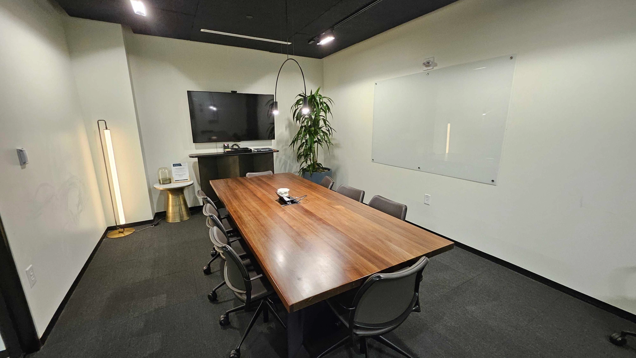 A coworking meeting room in Austin with a wooden table and chairs.