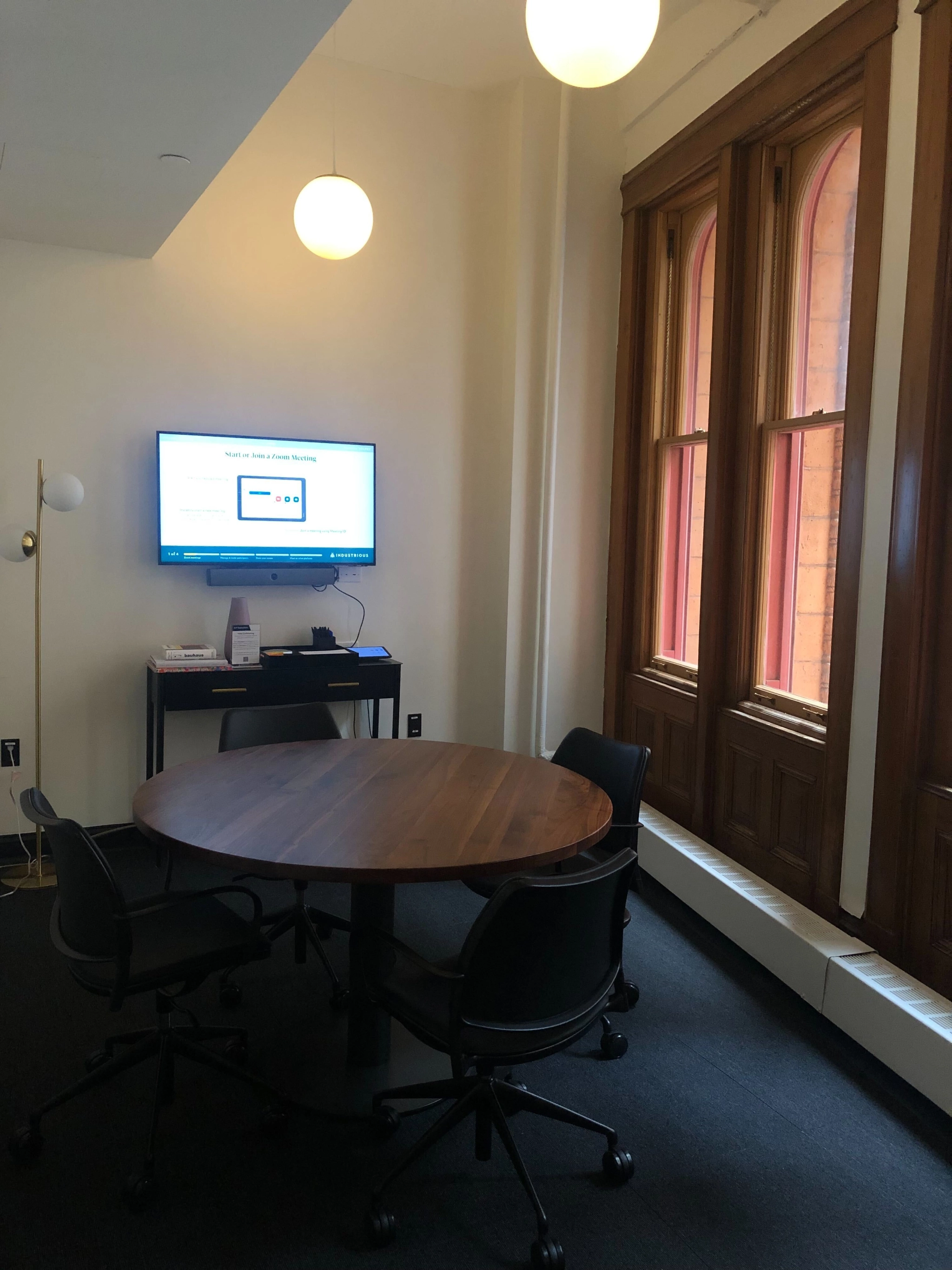 Un espace de travail avec table et chaises, idéal pour une utilisation en coworking ou bureau, et équipé d'une télévision.