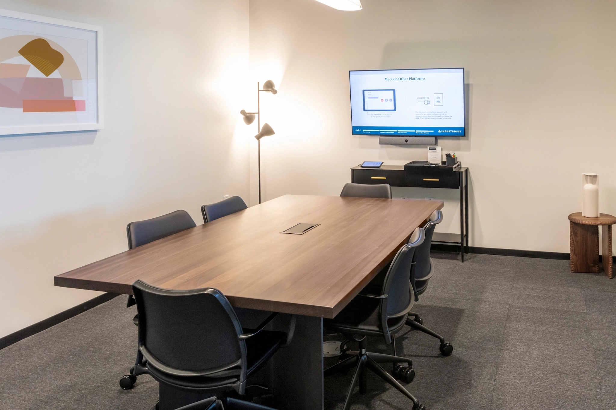 Een coworking-werkruimte in Chapel Hill met een conferentieruimte uitgerust met een tafel, stoelen en tv.