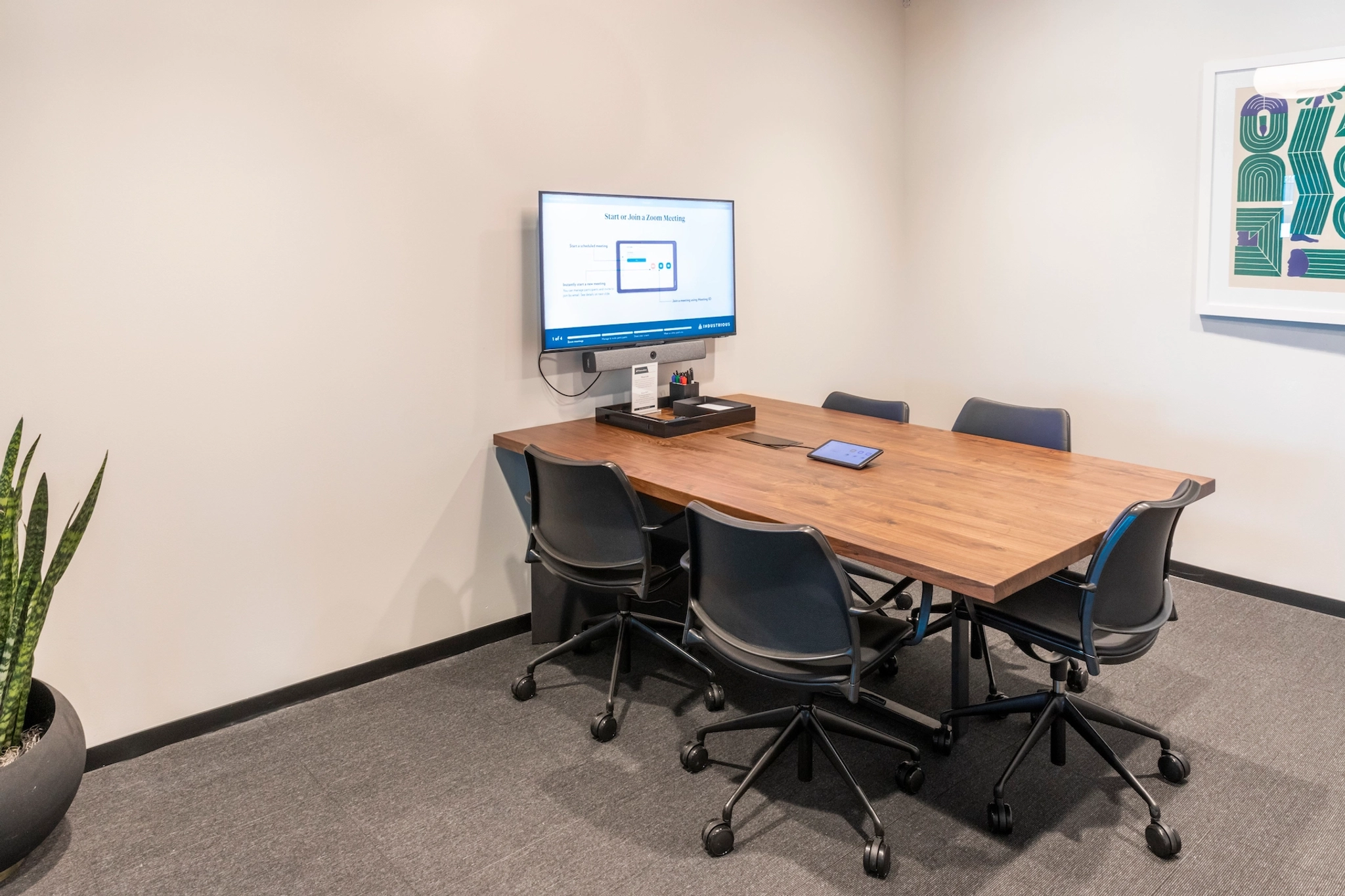 A Chapel Hill workspace equipped with a meeting room featuring a table, chairs, and a TV.