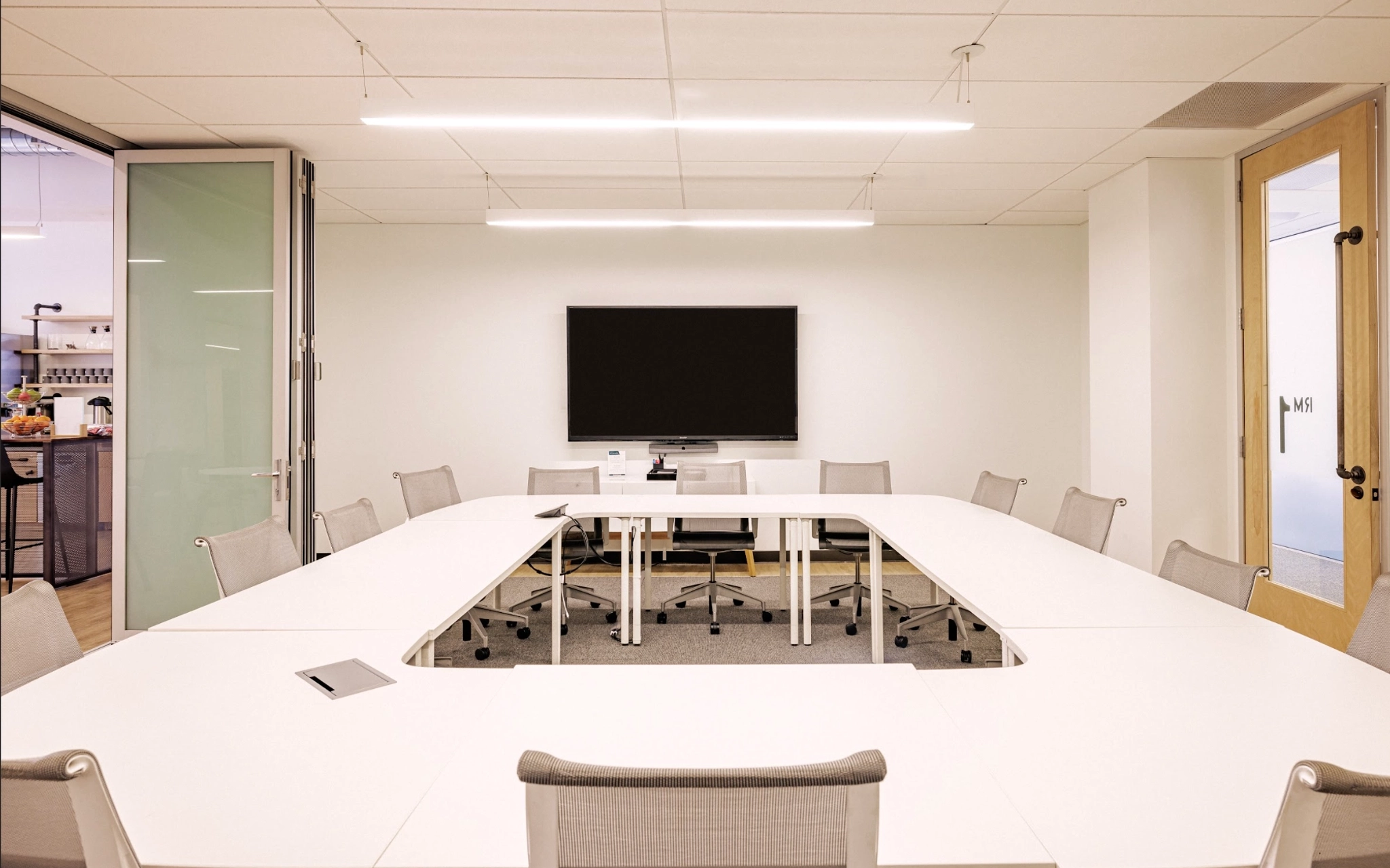 Une salle de conférence à San Francisco avec une table et des chaises blanches.