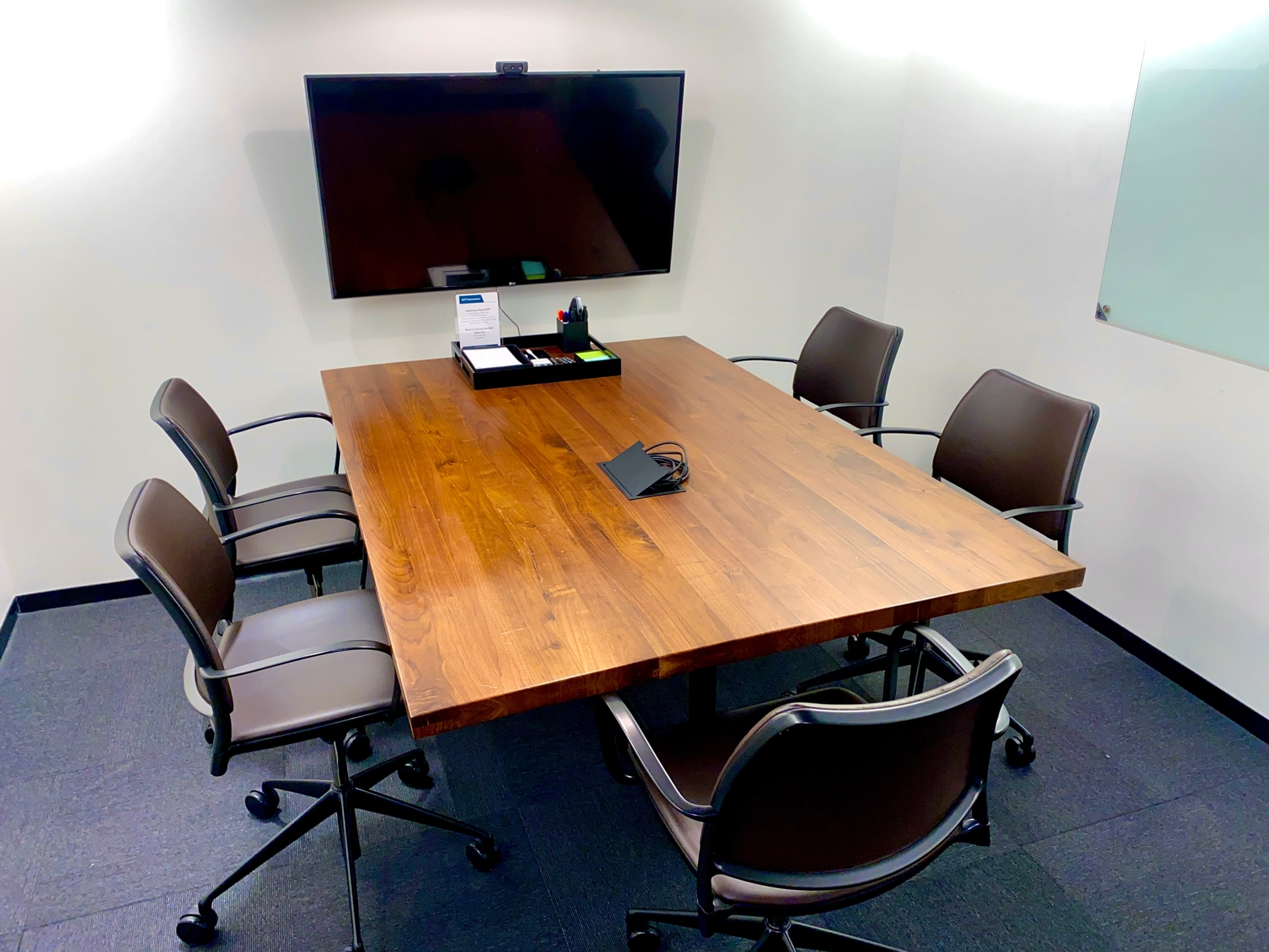 Une salle de conférence dans un bureau de Boston avec une table et des chaises en bois.