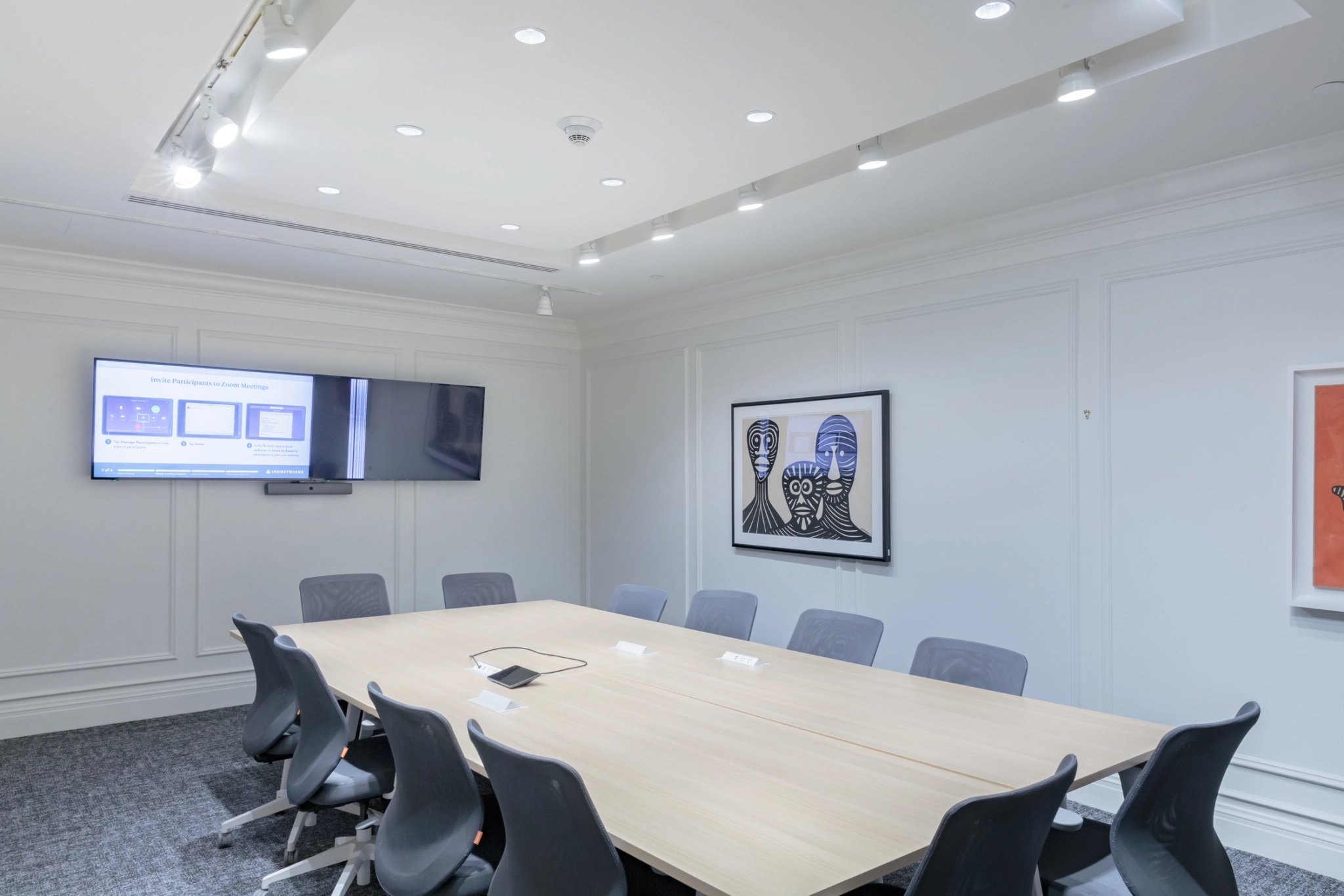 Un bureau salle de conférence à New York équipé d'une table, de chaises et d'une télévision.