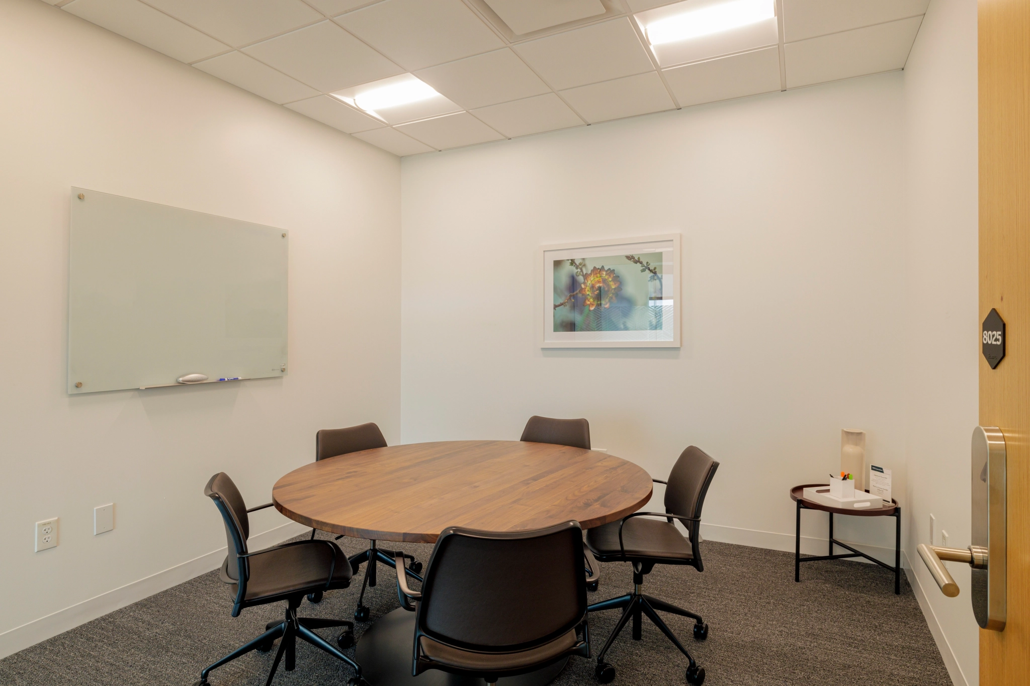 Une salle de réunion de coworking à Atlanta avec une table ronde et des chaises.