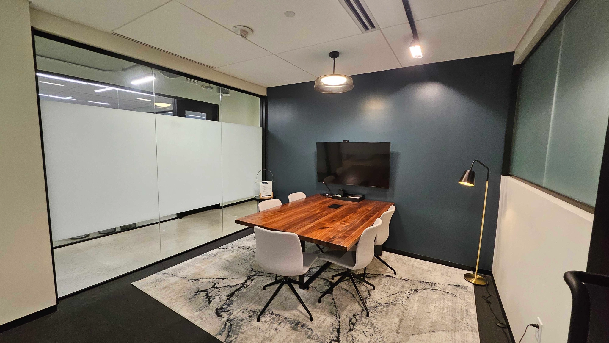 Un espace de coworking à Austin avec une salle de conférence meublée d'une table et de chaises.