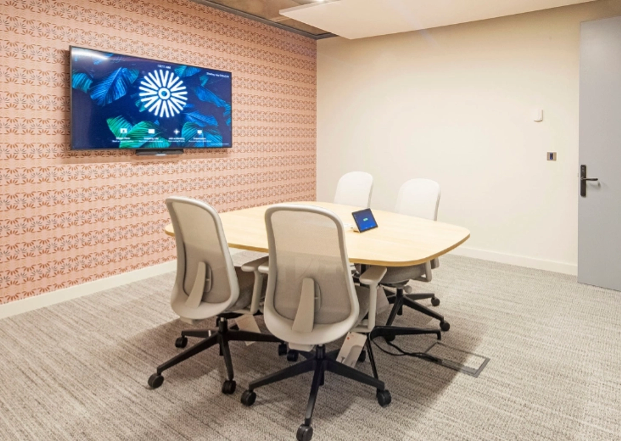A Manchester coworking meeting room with a tv on the wall.