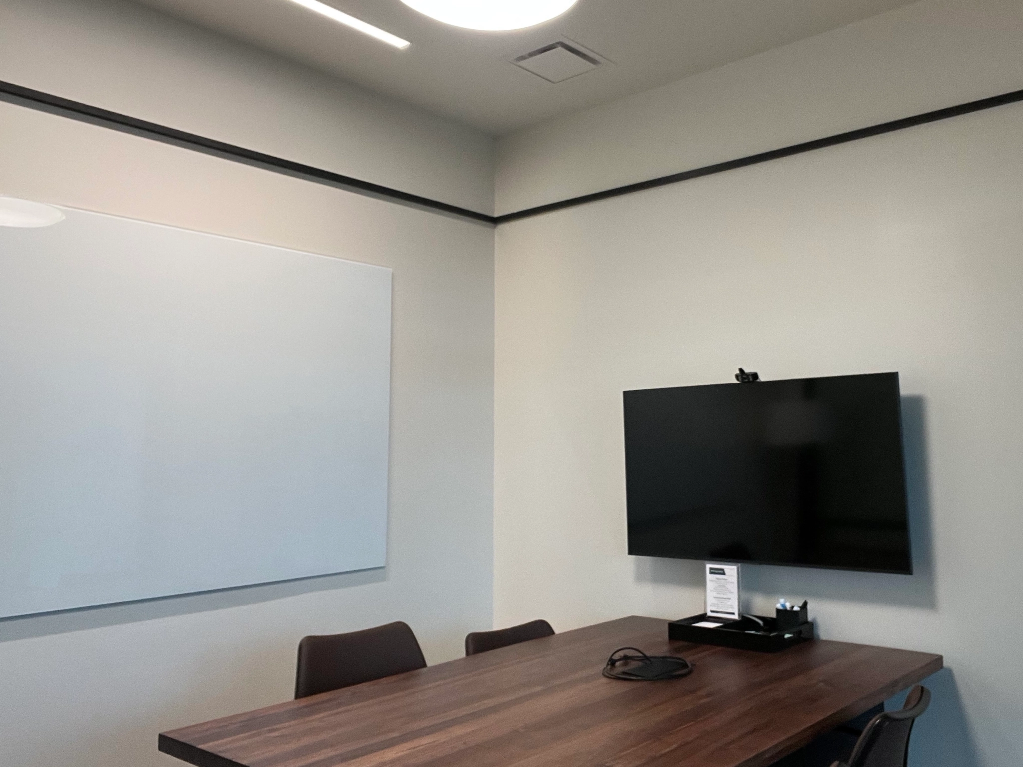 A Seattle conference room equipped with a whiteboard and TV, perfect for office meetings or collaborative workspace.