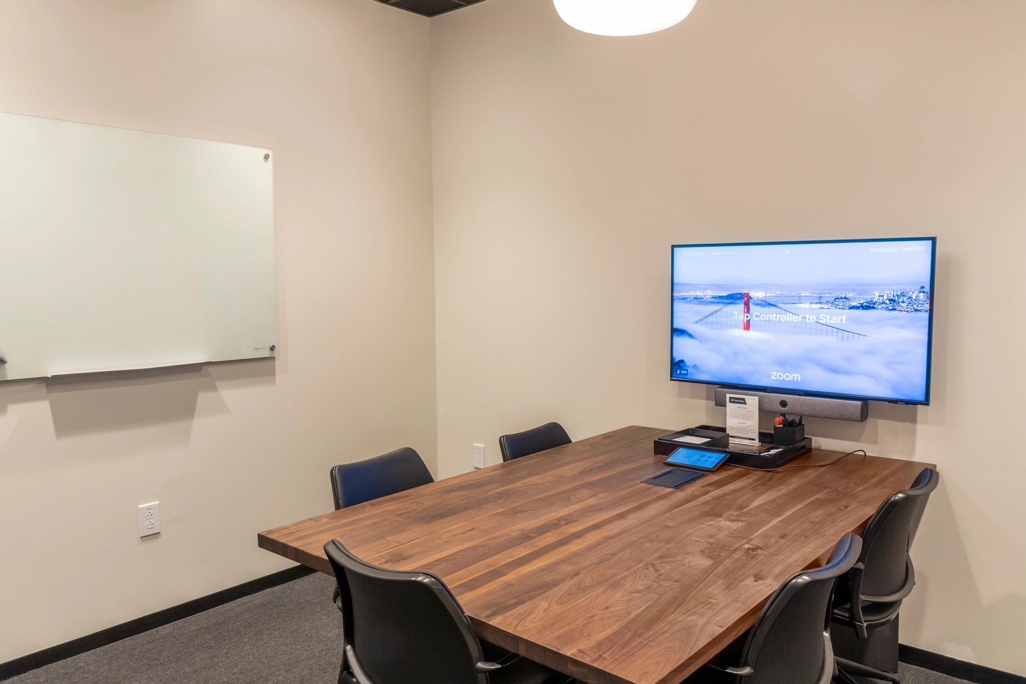 Een coworking-kantoor in Chapel Hill uitgerust met een vergaderruimte met een aan de muur gemonteerde tv.