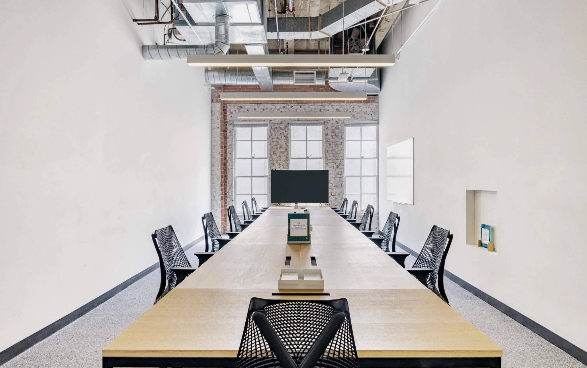 Un bureau salle de réunion avec une longue table et des chaises.