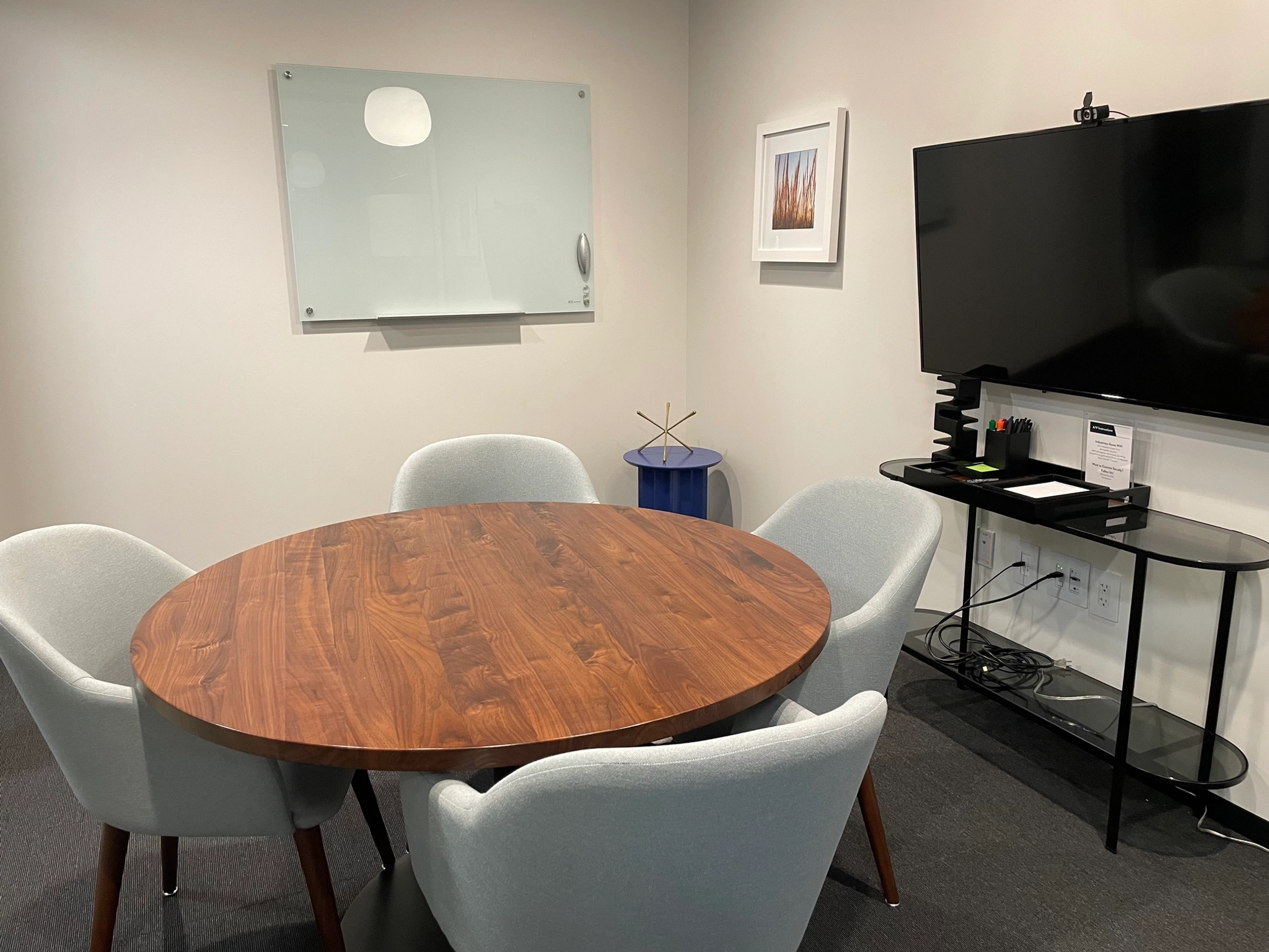 A Washington coworking meeting room equipped with a table, chairs, and a TV.