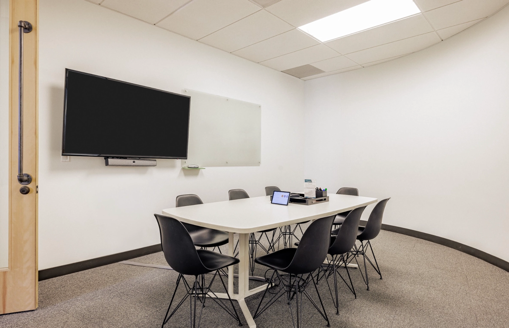 Une salle de réunion de coworking à San Francisco équipée d'une télévision au mur.