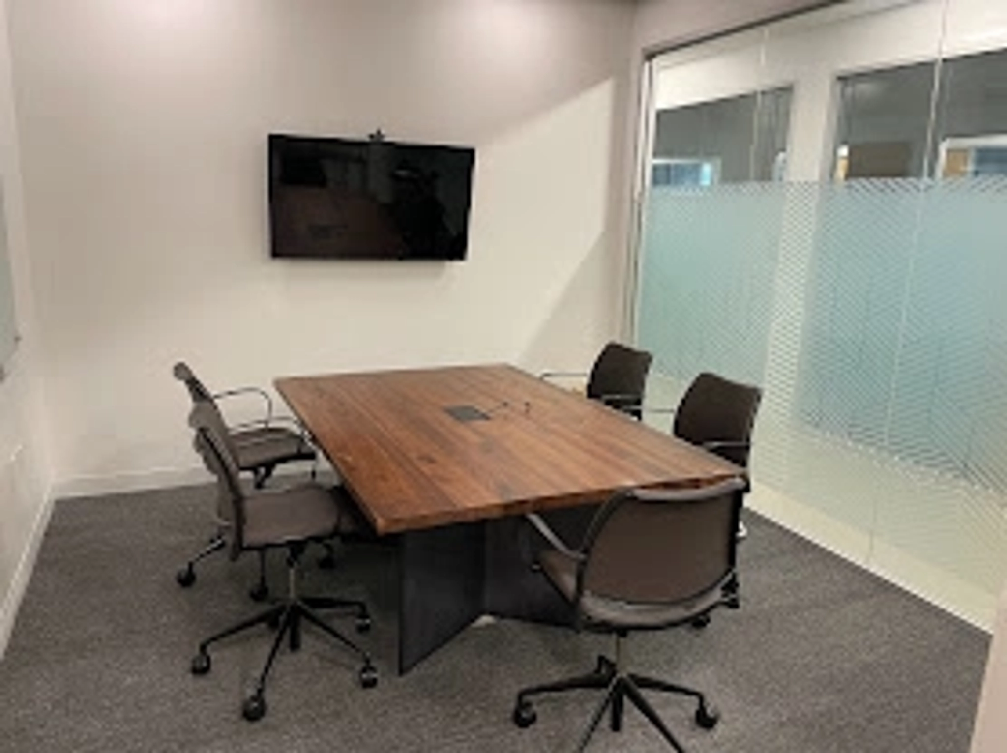 A coworking meeting room in Atlanta with a conference table and chairs.