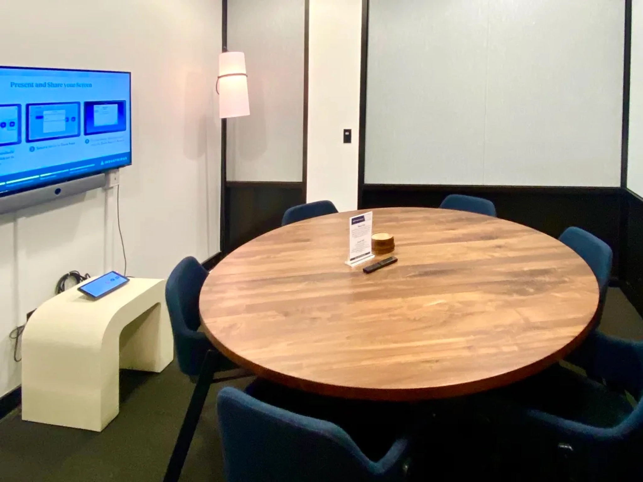 Une salle de réunion à New York équipée d'une table, de chaises et d'une télévision.