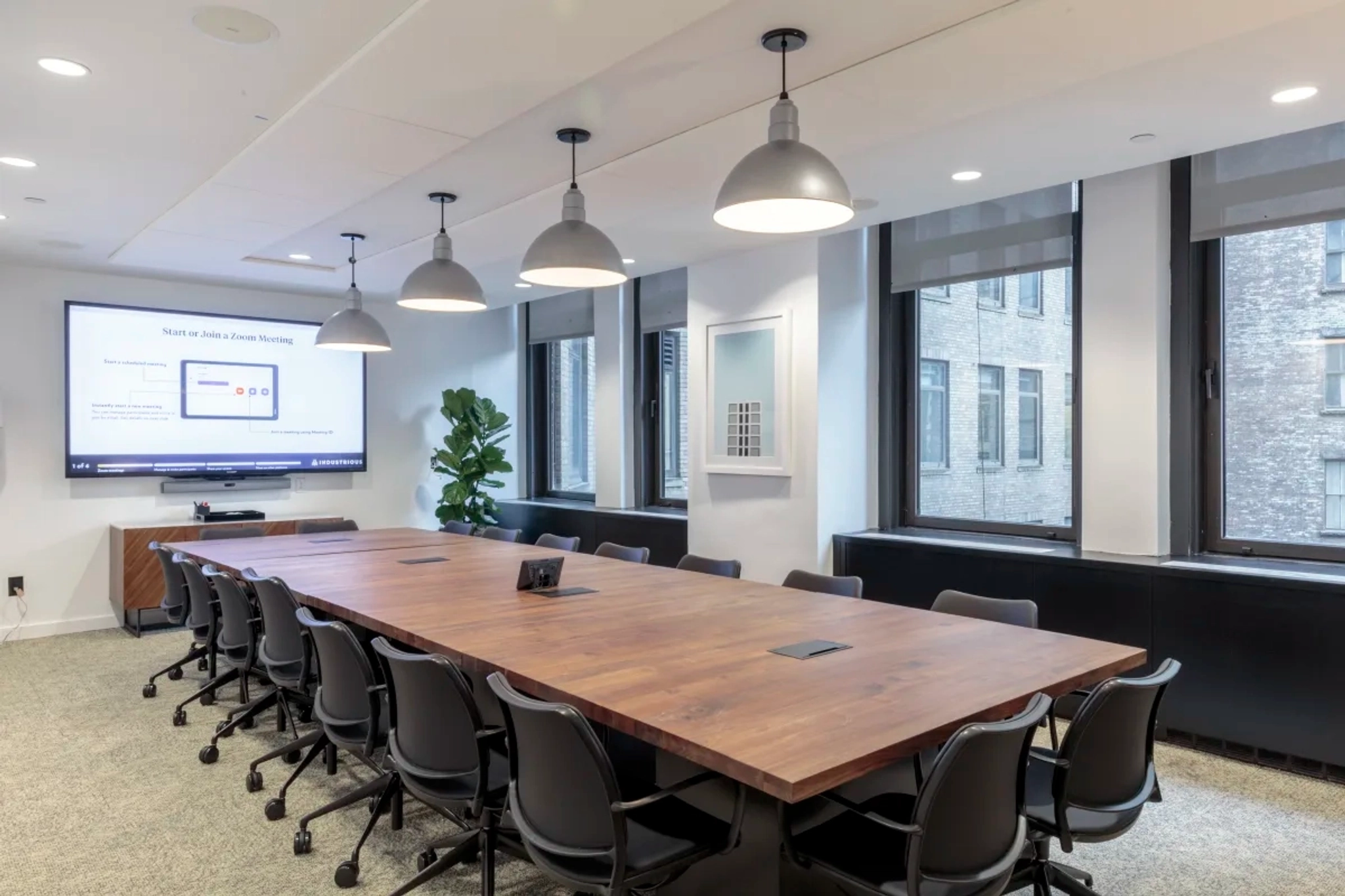 A spacious conference room with a large table and chairs, perfect for meetings and coworking.