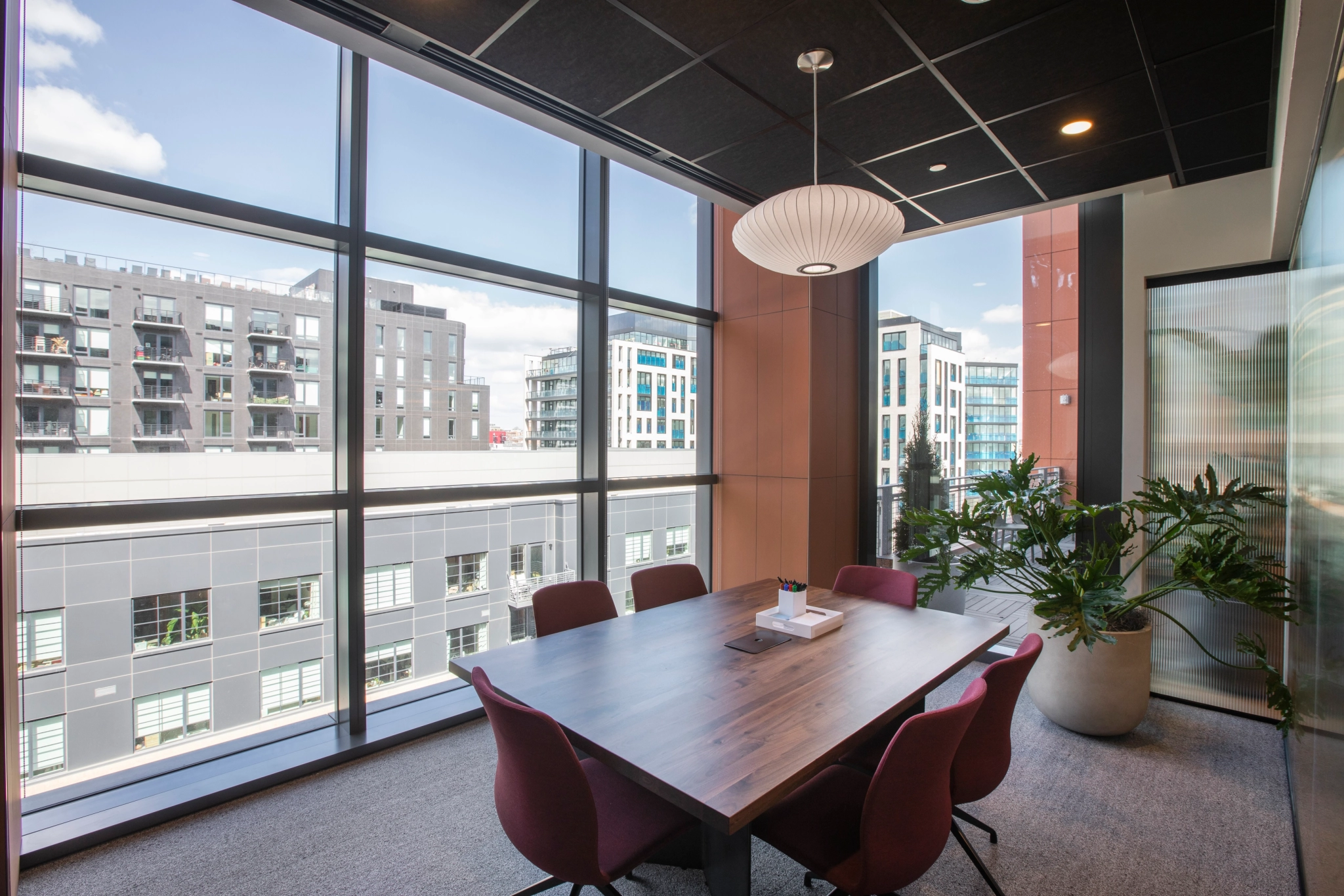 A meeting room with a table and chairs and a view of the city.