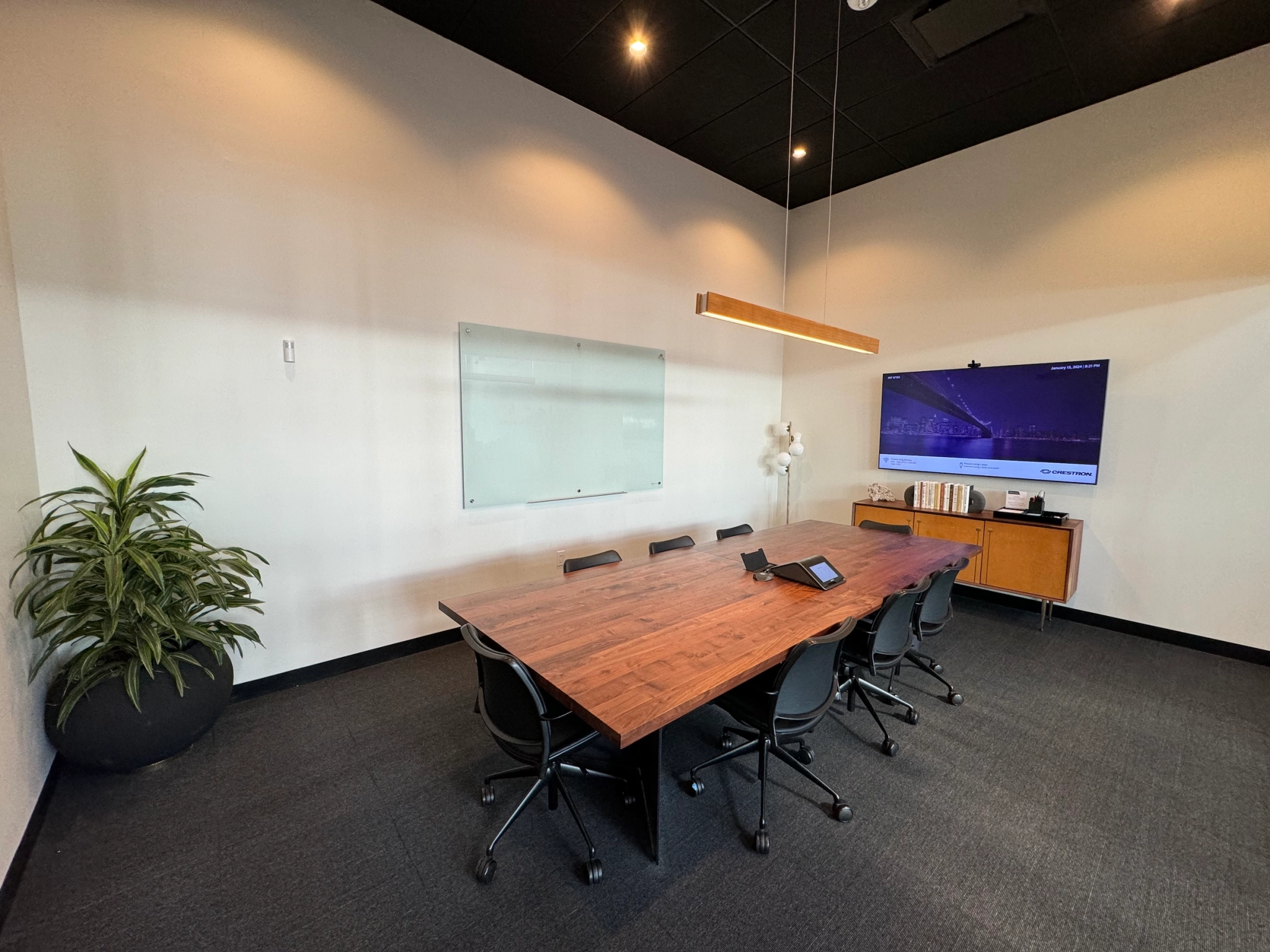 Espace de travail : Une salle de conférence avec une table, des chaises et une télévision, idéale pour des réunions ou un travail collaboratif.