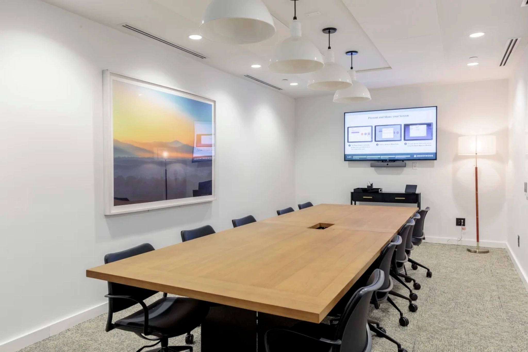 A meeting room with a large table and chairs.